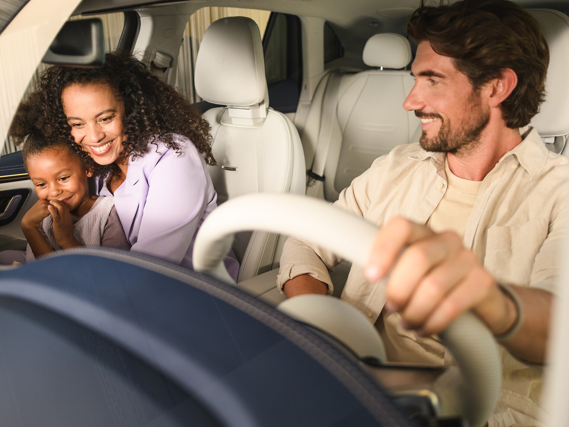 Twee personen en een kind in een Mercedes-Benz voertuig.​