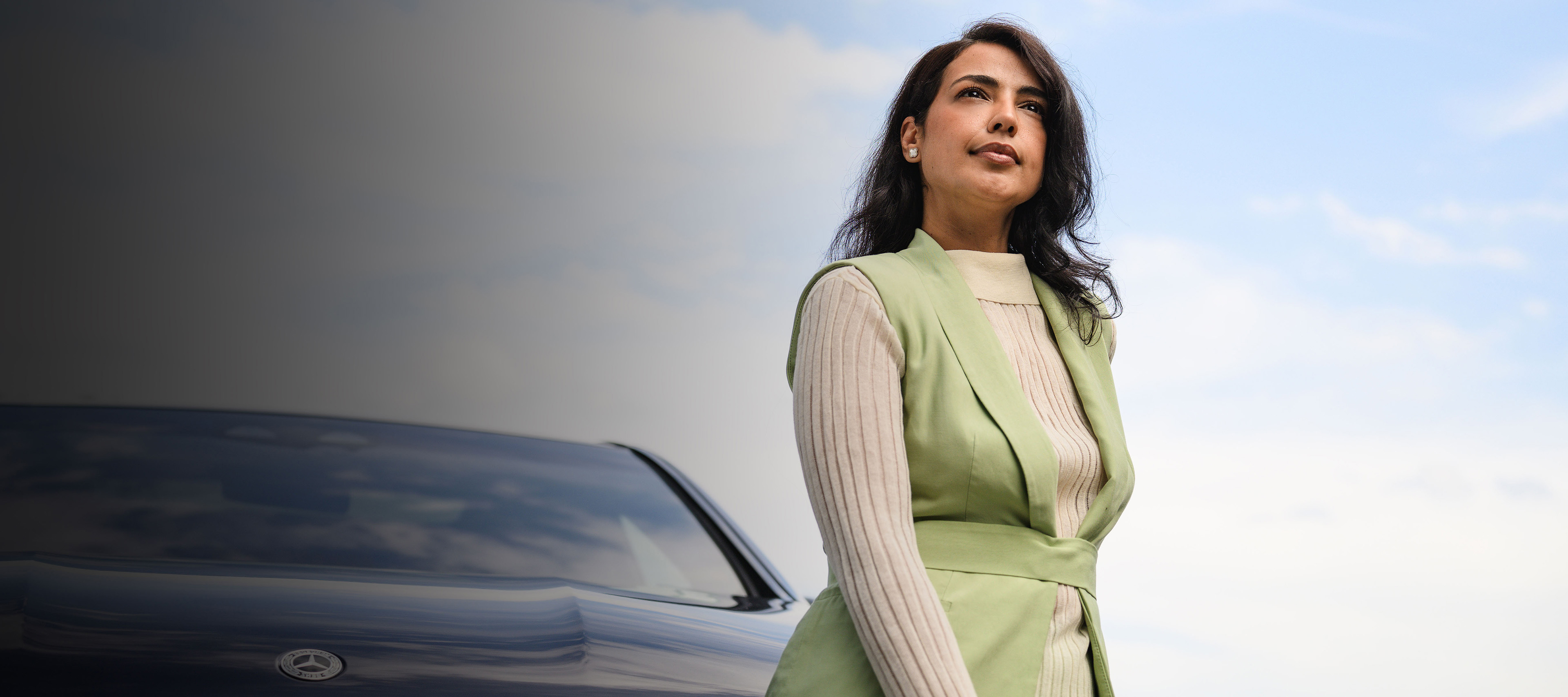 Procédure de fin de contrat pour votre Mercedes-Benz Une personne debout devant un véhicule Mercedes-Benz, regardant au loin.