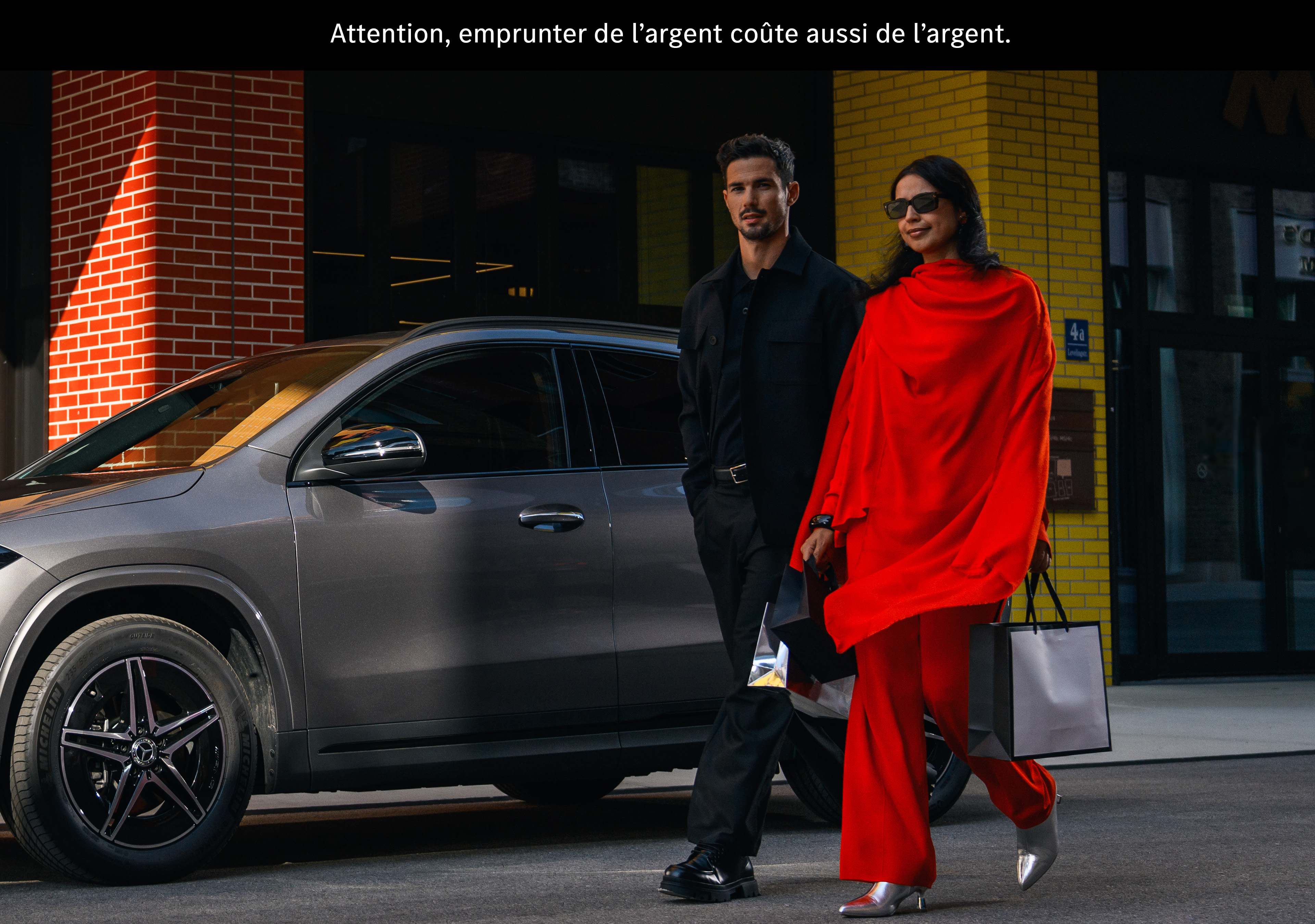 Services financiers pour votre Mercedes-Benz Un couple passe devant une Mercedes EQA.