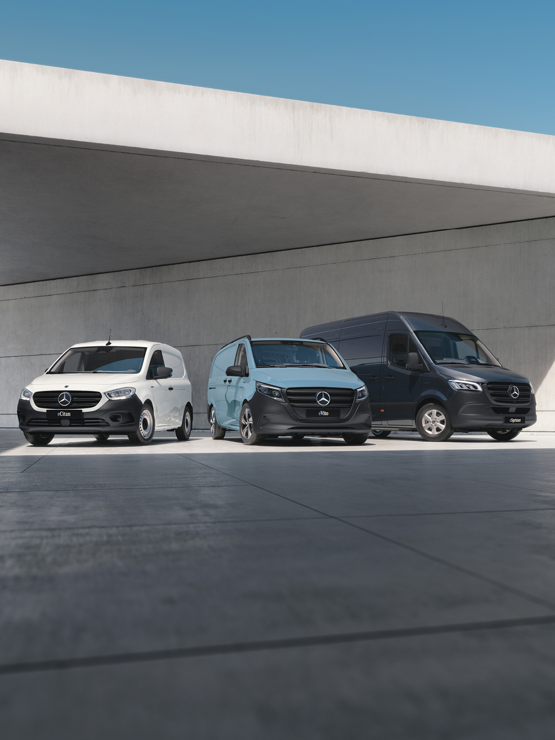Drie Mercedes-Benz bestelwagens geparkeerd onder een overkapping.