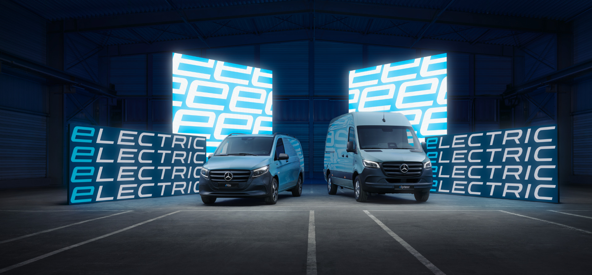 Elektrische bestelwagens | Mercedes-Benz Bedrijfsvoertuigen De eSprinter en eVito, elektrische bedrijfsvoertuigen Mercedes-Benz, staan samen in een stedelijke omgeving.
