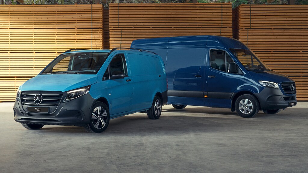 Deux fourgons Mercedes-Benz bleus dans un entrepôt en bois.