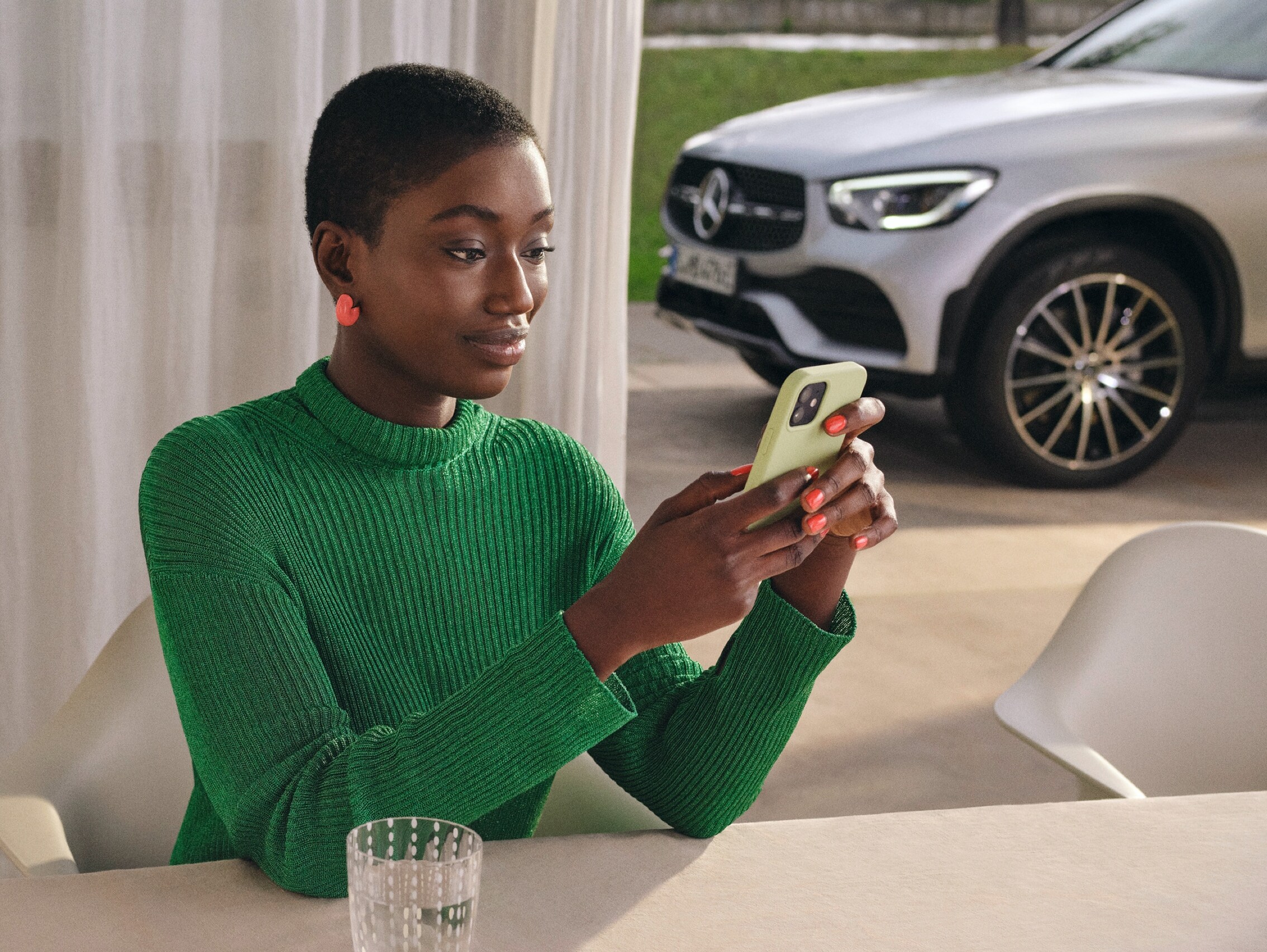 Een vrouw koppelt de Mercedes-Benz Adapter via de Mercedes-Benz Adapter-app aan een smartphone.