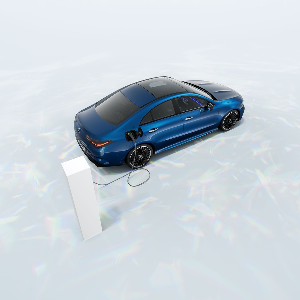 Zicht op een Mercedes-Benz CLA 250 e Coupé met EQ-hybridetechnologie, geparkeerd bij een laadstation.