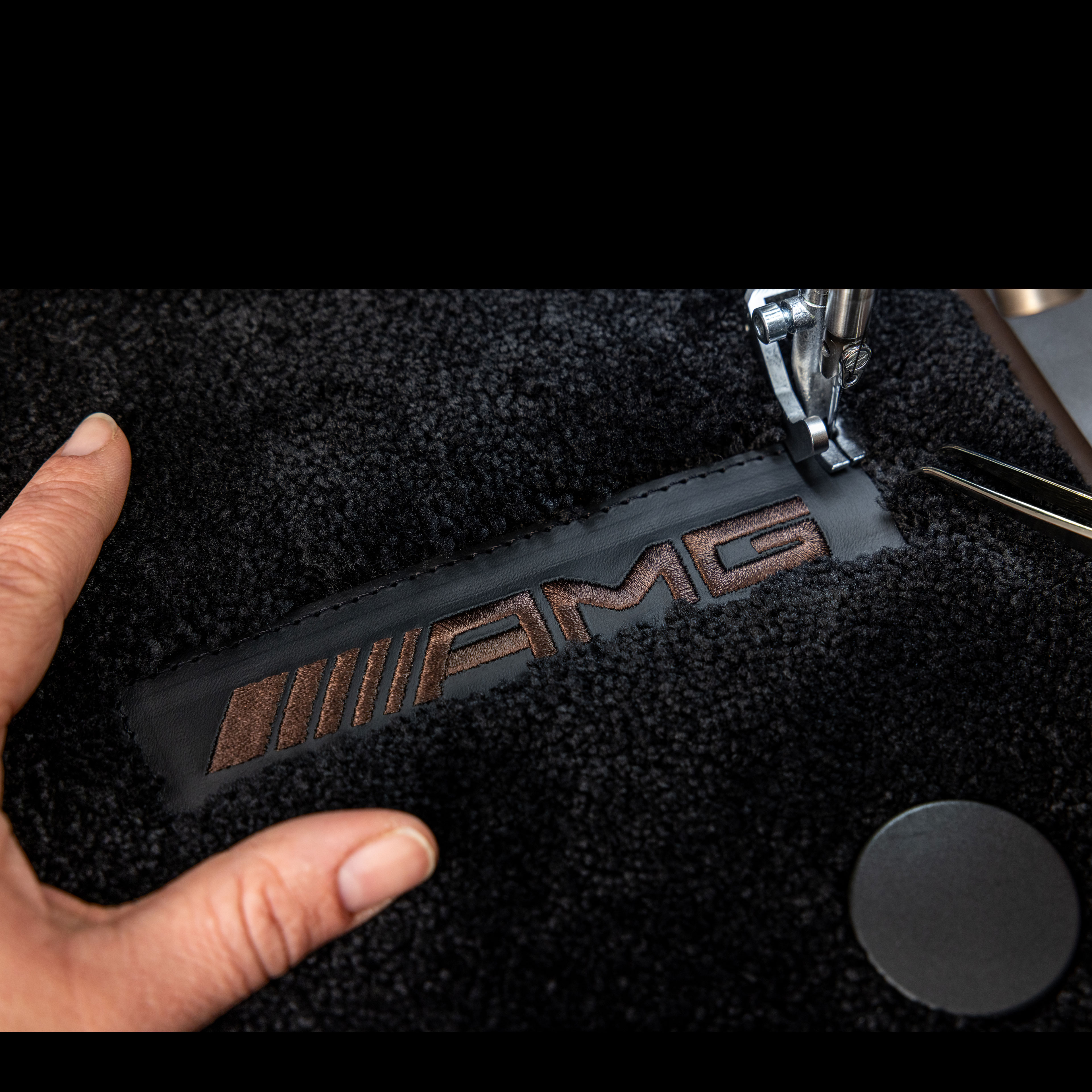 MANUFAKTUR | Mercedes-AMG MANUFAKTUR-letters op een donker oppervlak in een Mercedes-AMG.