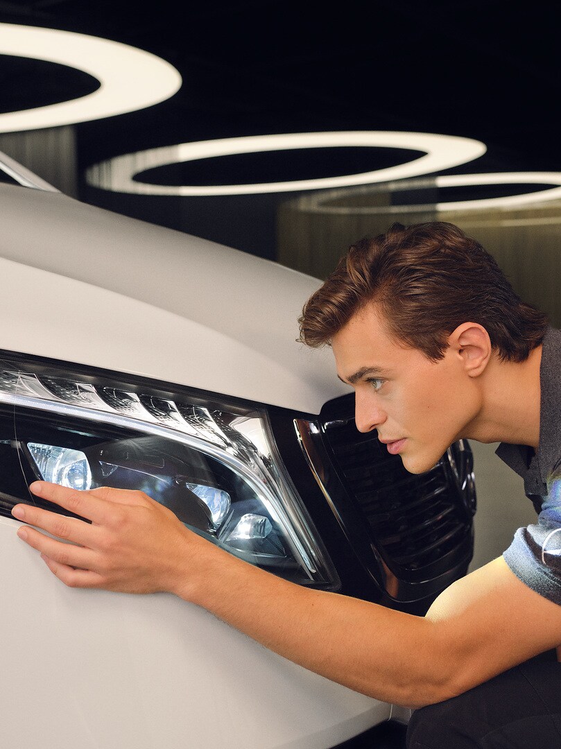 Een servicetechnicus controleert de koplamp van een Mercedes-Benz.