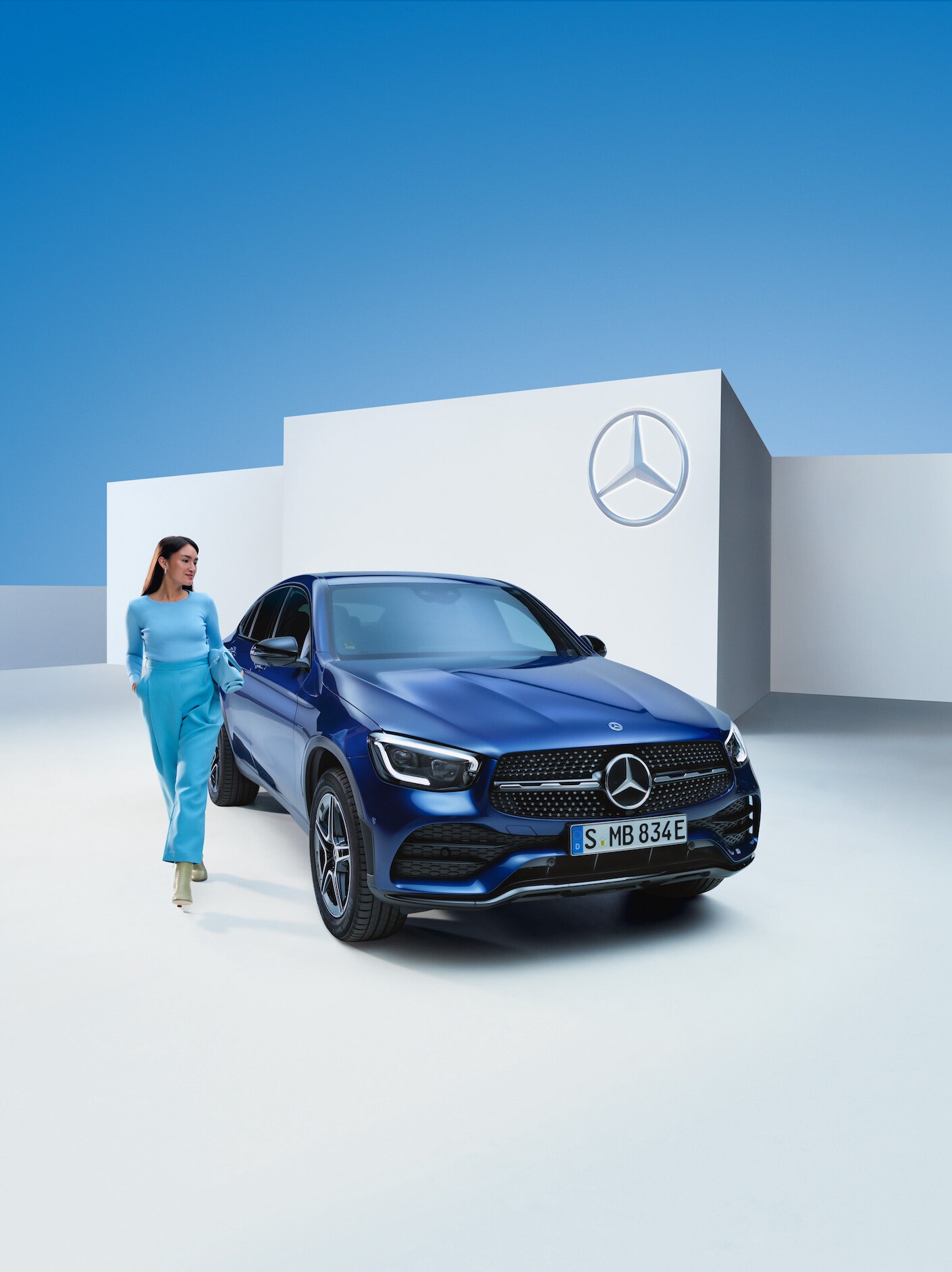 Een vrouw staat naast haar Mercedes-Benz.