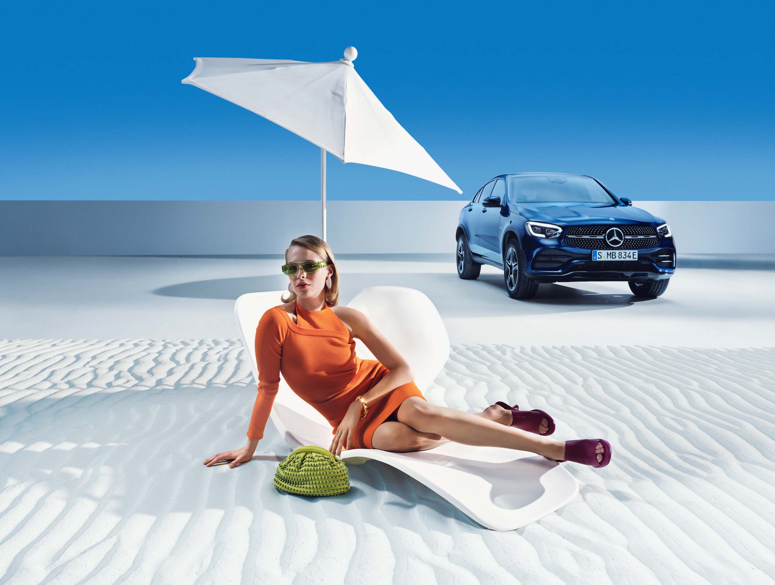 Mercedes-Benz | Originele verzorgingsproducten Een vrouw staat ontspannen op het strand voor haar Mercedes-Benz.