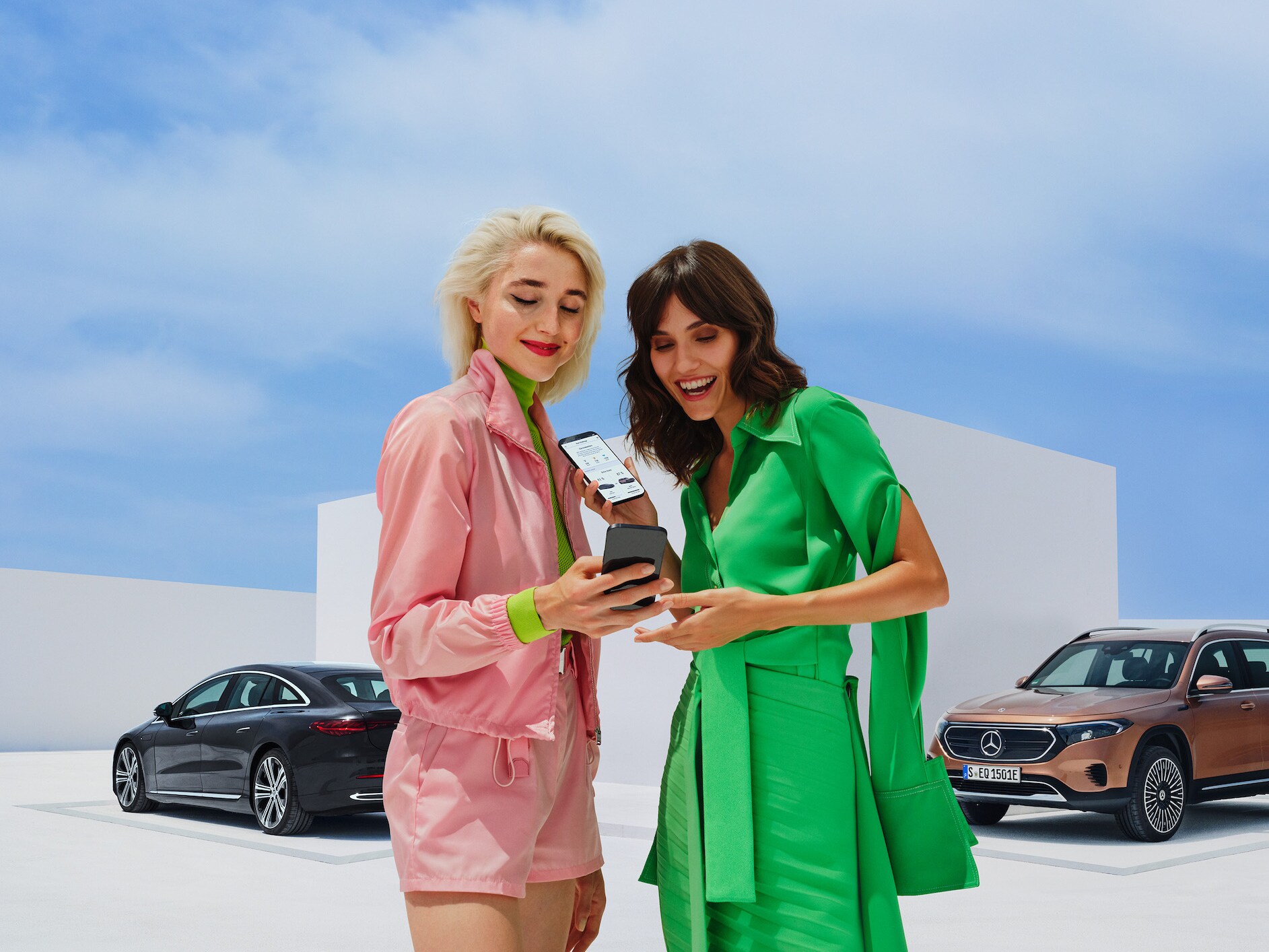 Twee vrouwen gebruiken de Mercedes-Benz Service-app op hun smartphones.