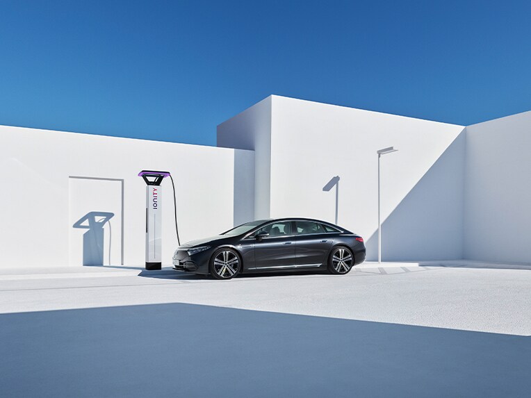 Une Mercedes-Benz EQS à une borne de recharge.