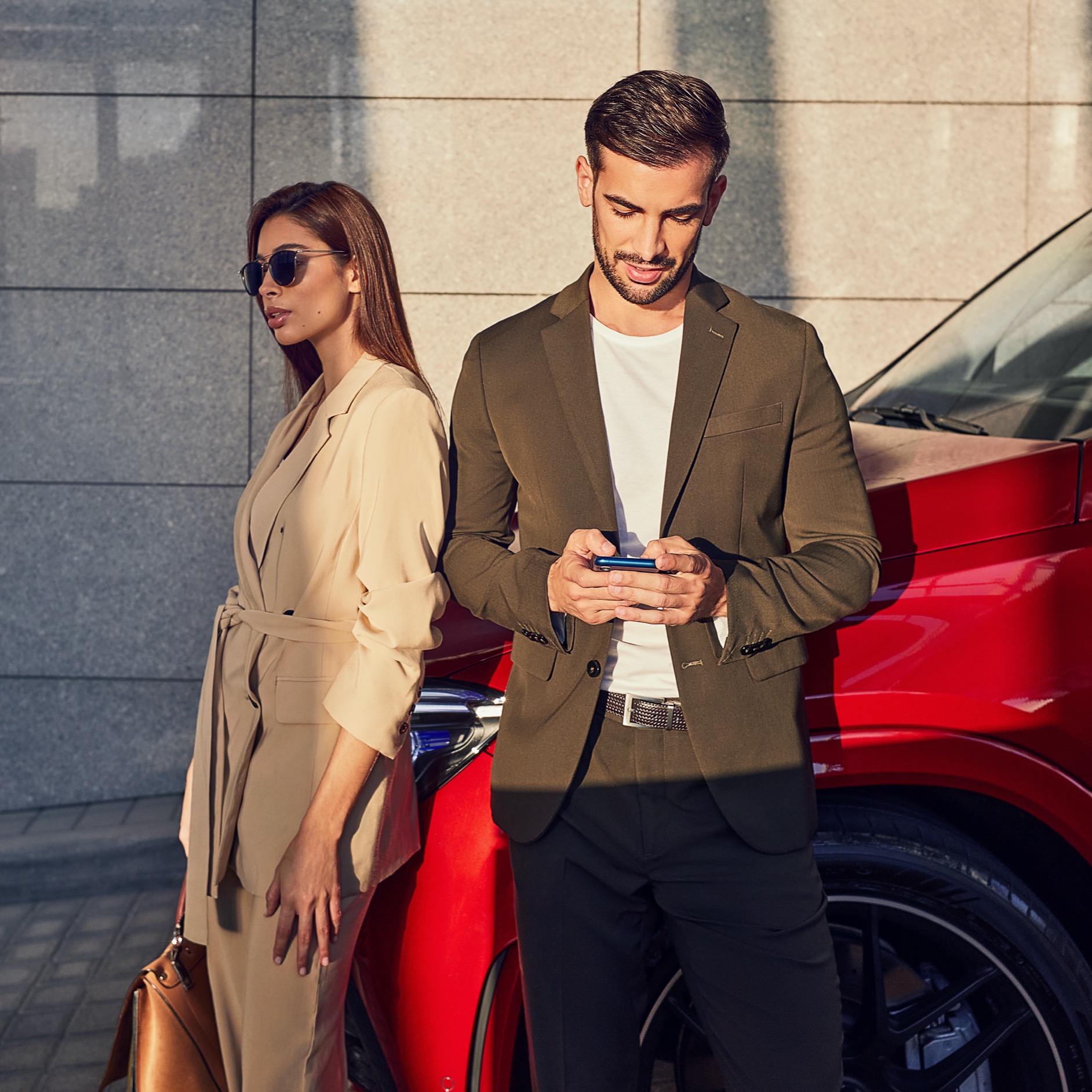 Une femme et un homme sont appuyés contre une Mercedes-Benz. L’homme est connecté au véhicule via son smartphone et des offres digitales. Une femme et un homme sont appuyés contre une Mercedes-Benz. L’homme est connecté au véhicule via son smartphone et des offres digitales.