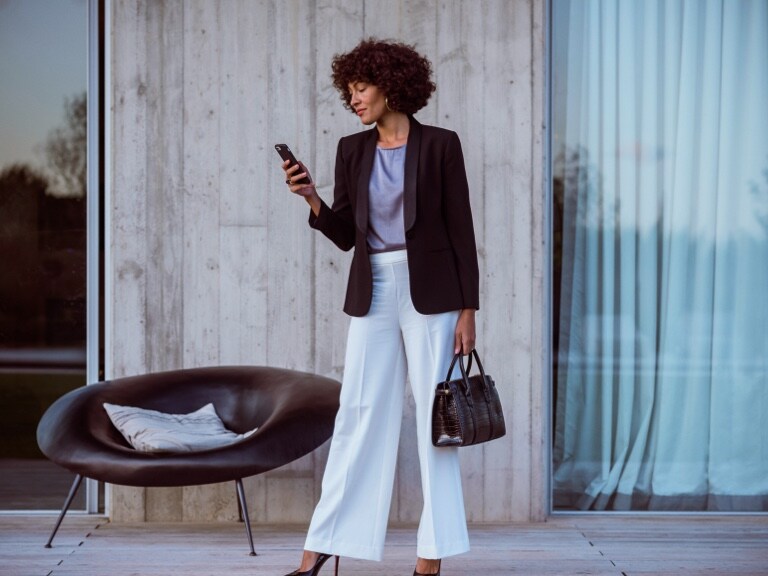 Une femme se connecte à sa Mercedes-Benz via son smartphone et l’application Mercedes me et vérifie si toutes les portes de sa Mercedes-Benz sont verrouillées à l’aide des offres digitales sur le thème Remote.