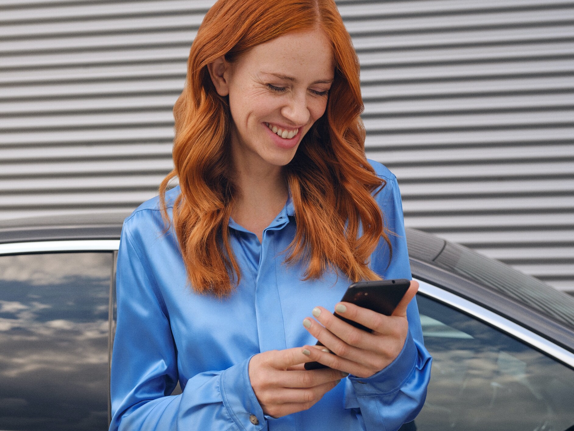 Une femme se connecte à sa Mercedes-Benz via l’application Mercedes-Benz sur son smartphone.