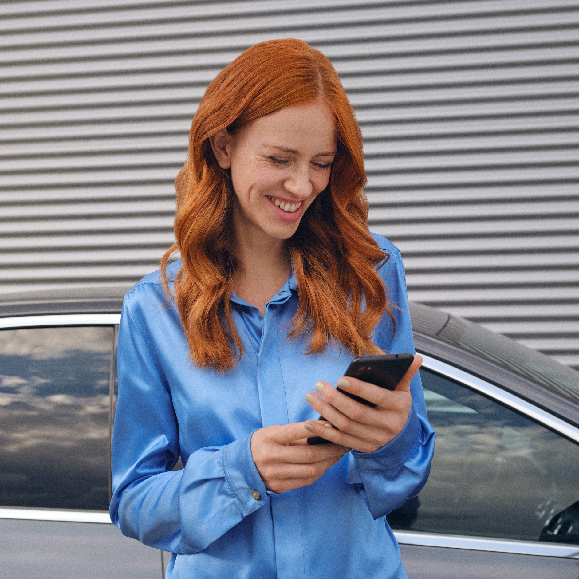 Une femme se connecte à sa Mercedes-Benz via l’application Mercedes-Benz sur son smartphone. Une femme se connecte à sa Mercedes-Benz via l’application Mercedes-Benz sur son smartphone.