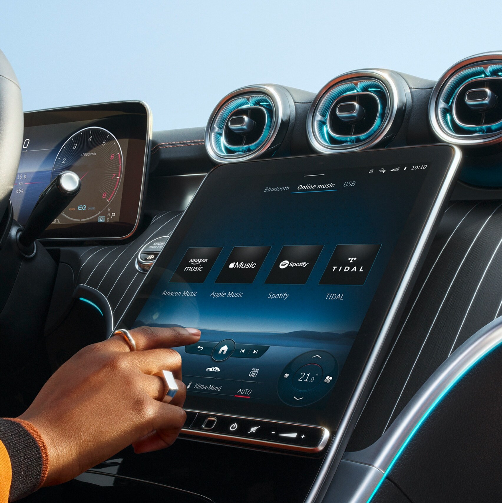 Une personne choisit sur le système multimédia MBUX d’une Mercedes-Benz parmi les services de streaming audio Amazon Music, Apple Music, Spotify et TIDAL celui qu’elle souhaite utiliser.