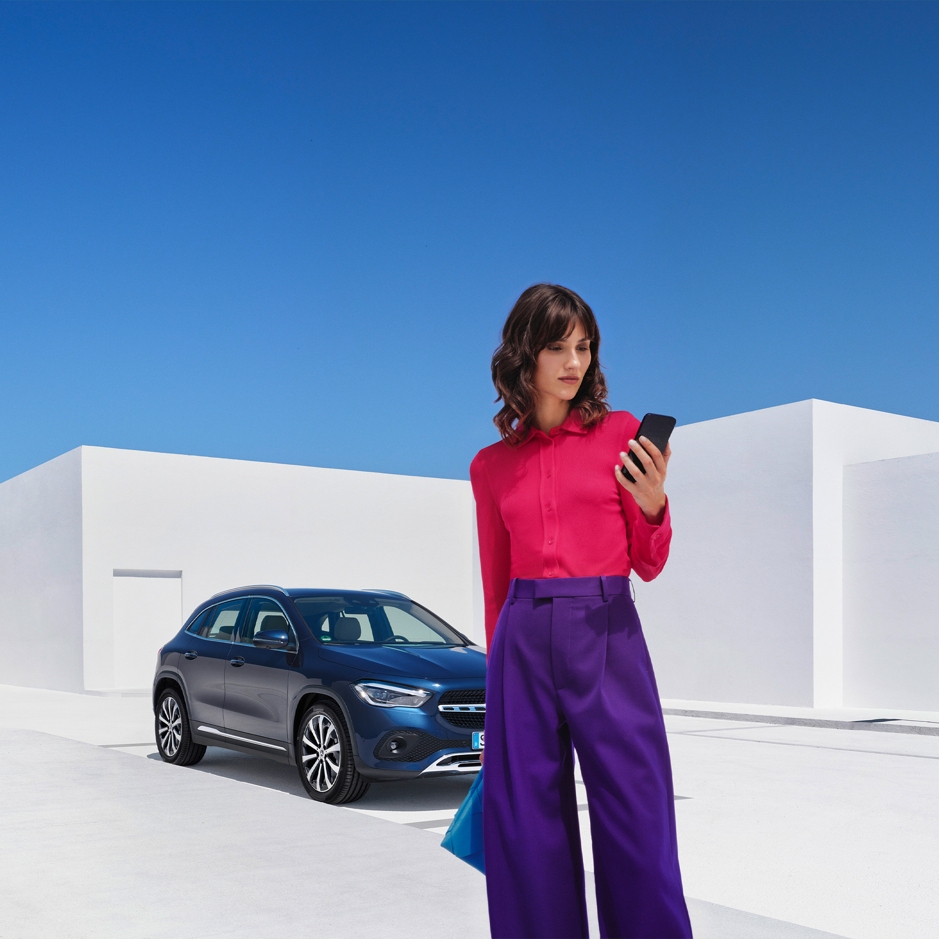 Zo werkt het | Mercedes-Benz Een vrouw brengt via de Mercedes-Benz app op haar smartphone een verbinding met haar Mercedes-Benz tot stand.