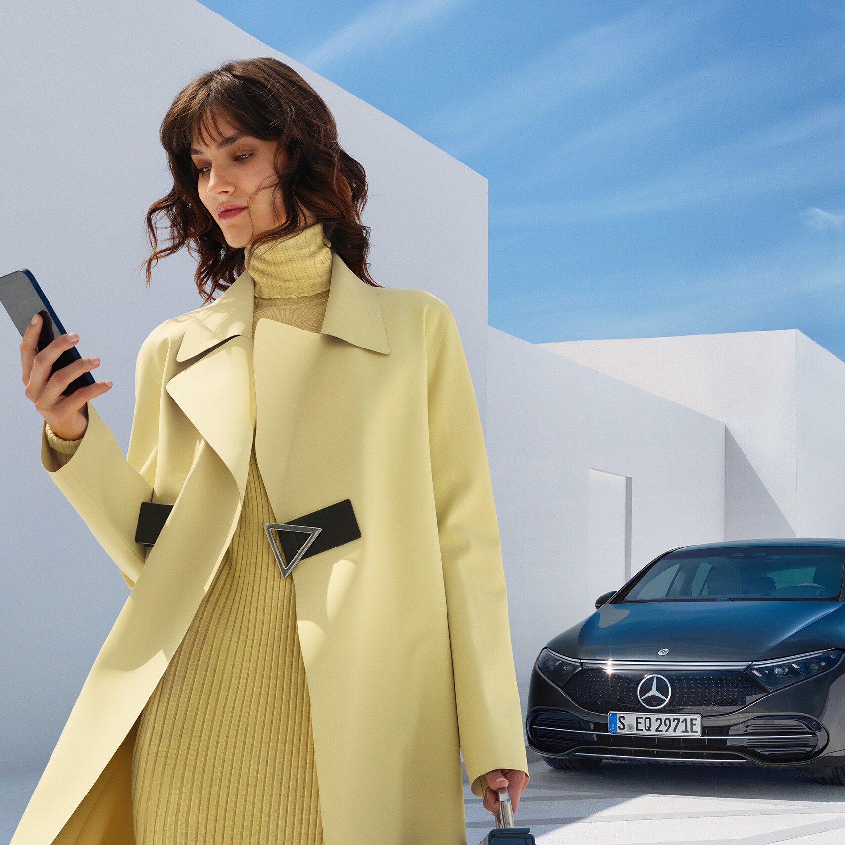 Een vrouw opent de Mercedes-Benz App op haar smartphone.