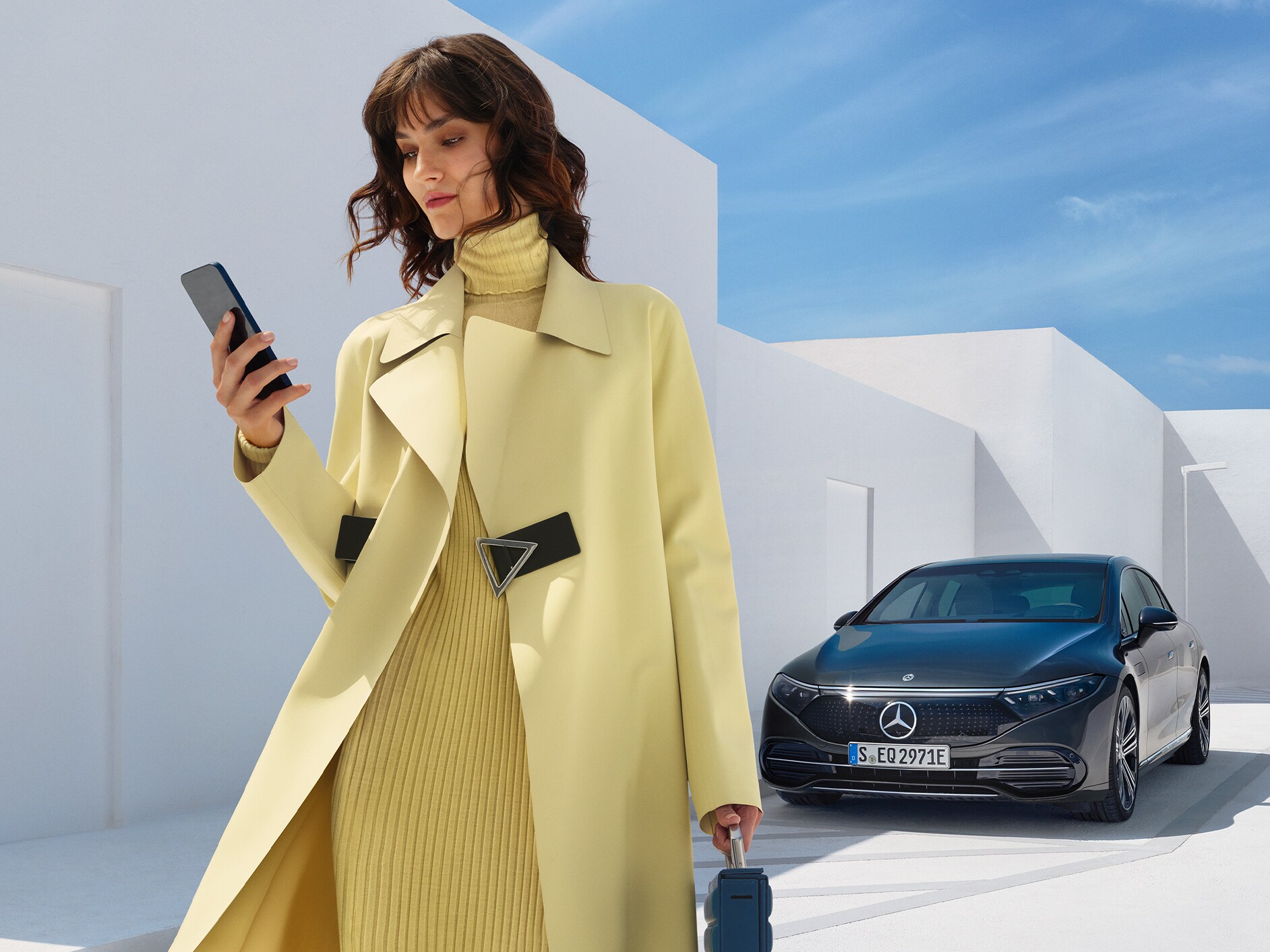 Een vrouw vóór de EQS Limousine van Mercedes-Benz.