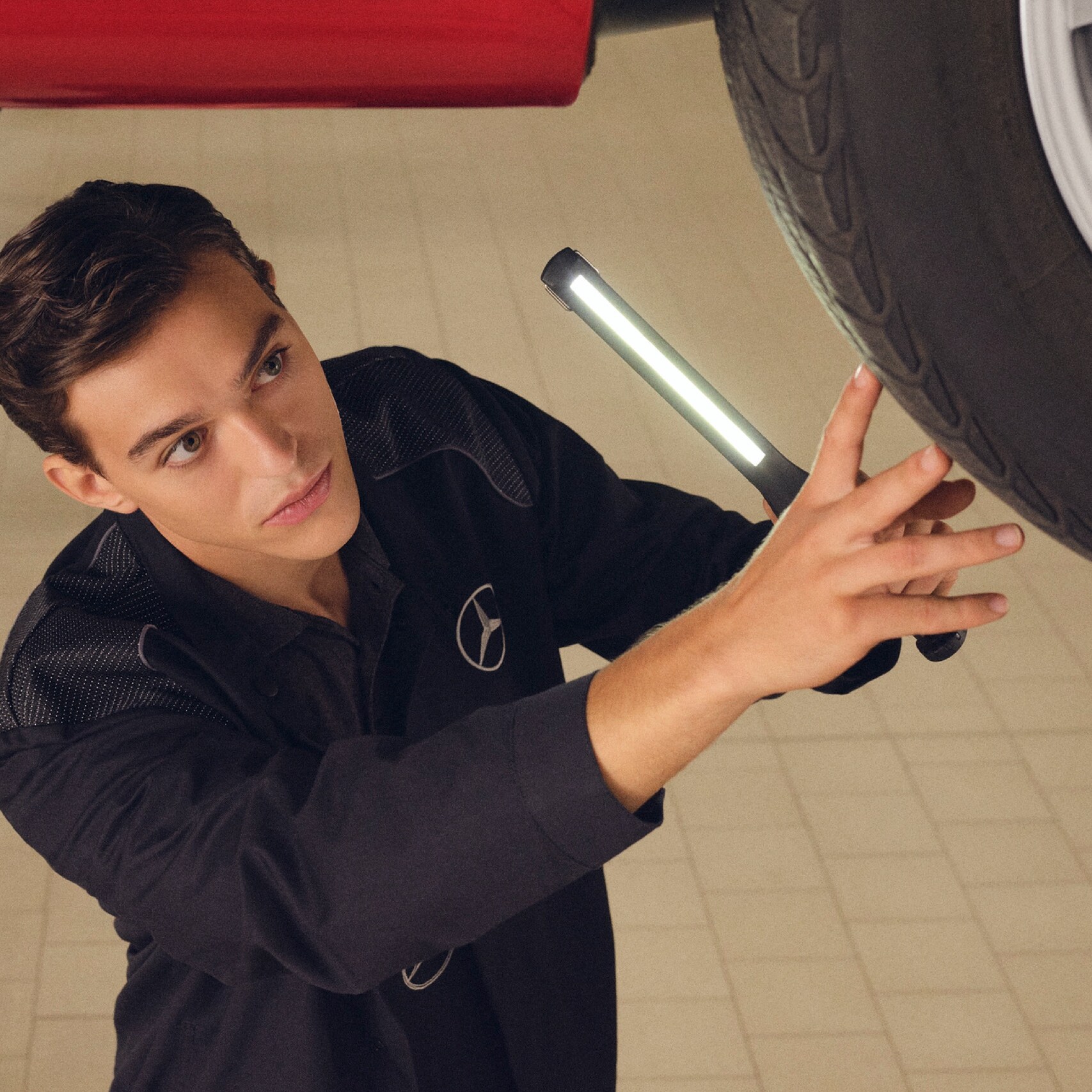 Un technicien Mercedes-Benz vérifie le dessous d'un véhicule.