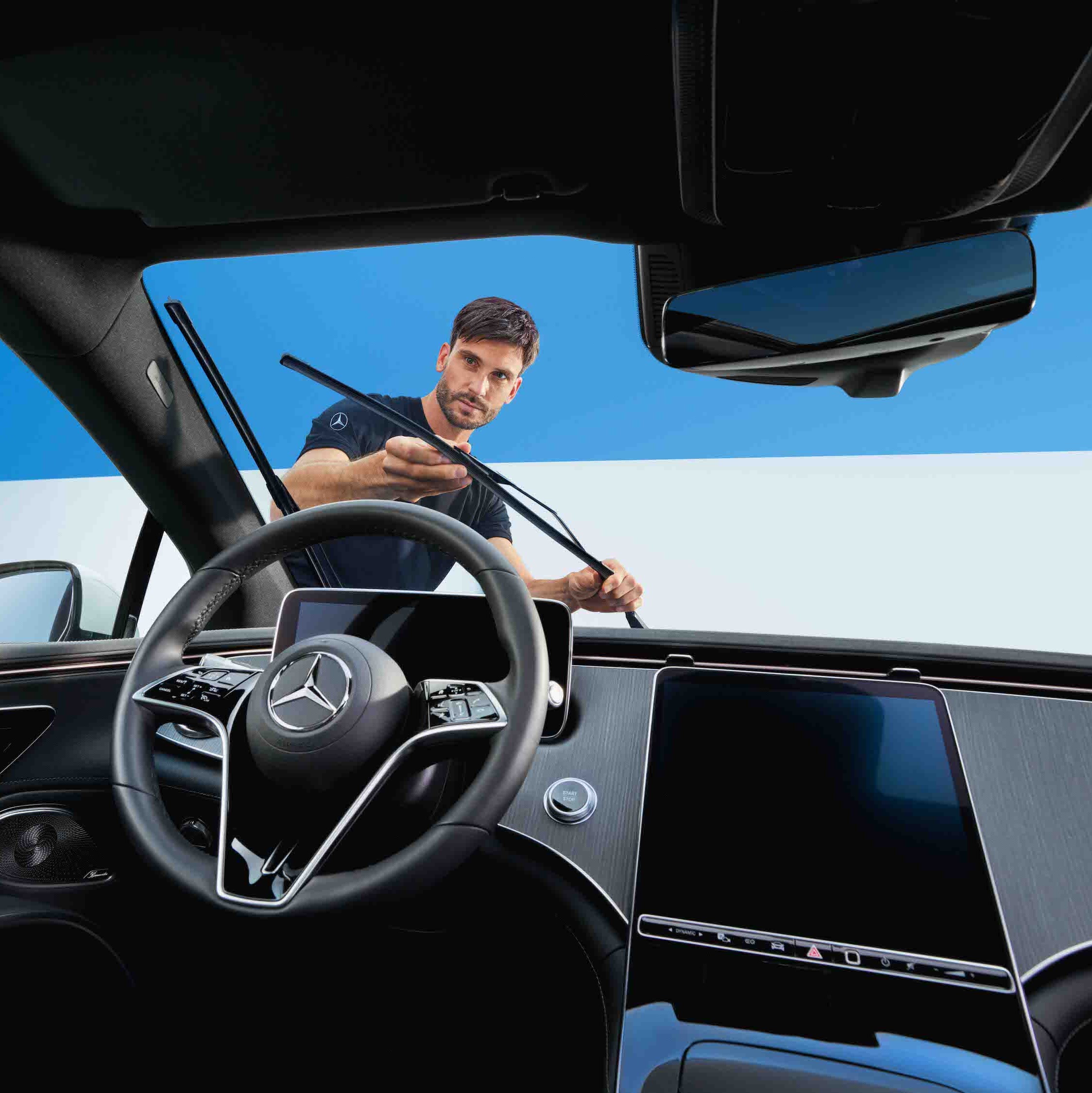 Een Mercedes-Benz monteur vervangt de ruitenwissers van een voertuig.