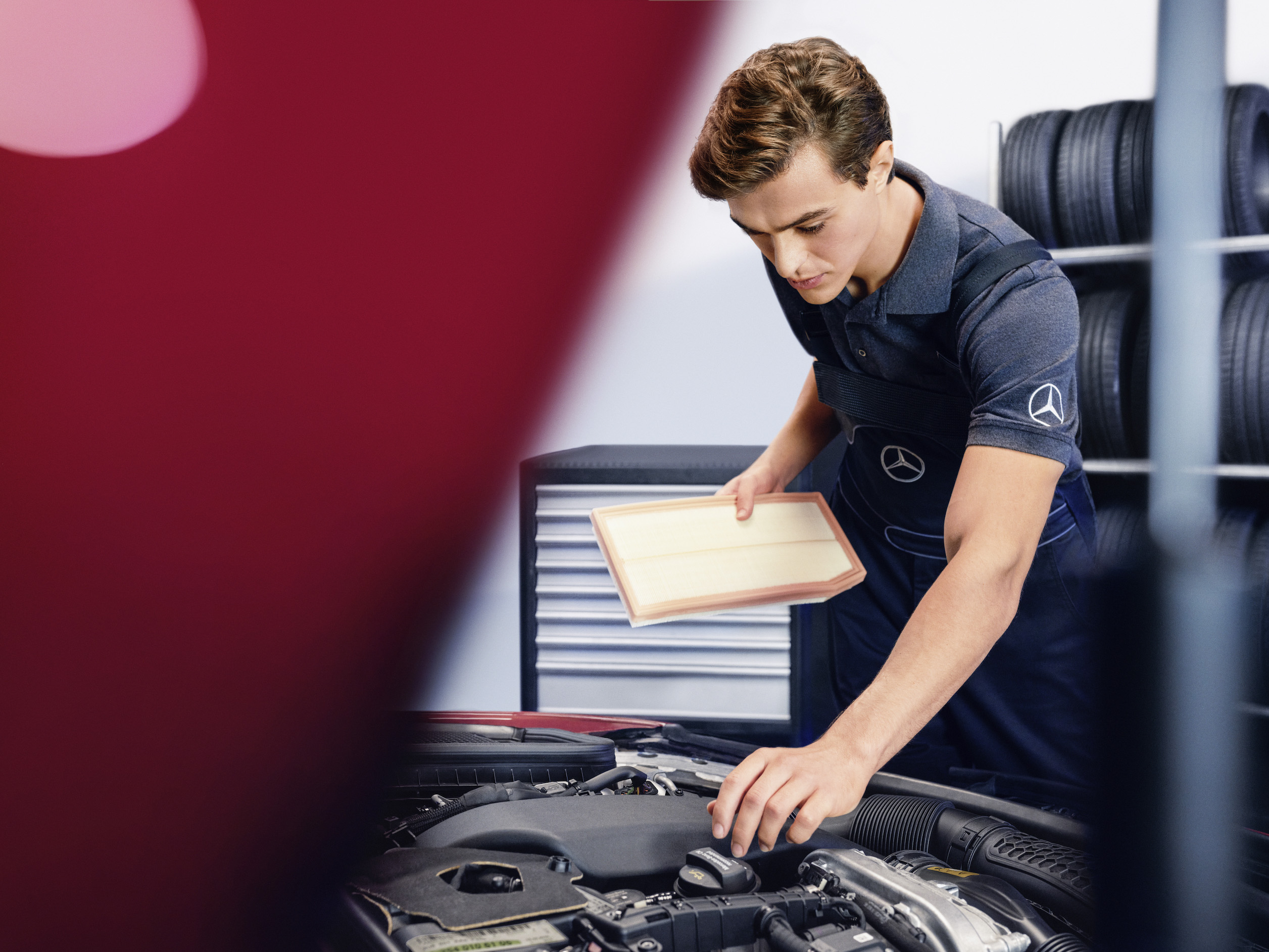 Originele onderdelen | Mercedes-Benz Een Mercedes-Benz technicus inspecteert de motorruimte van een auto.