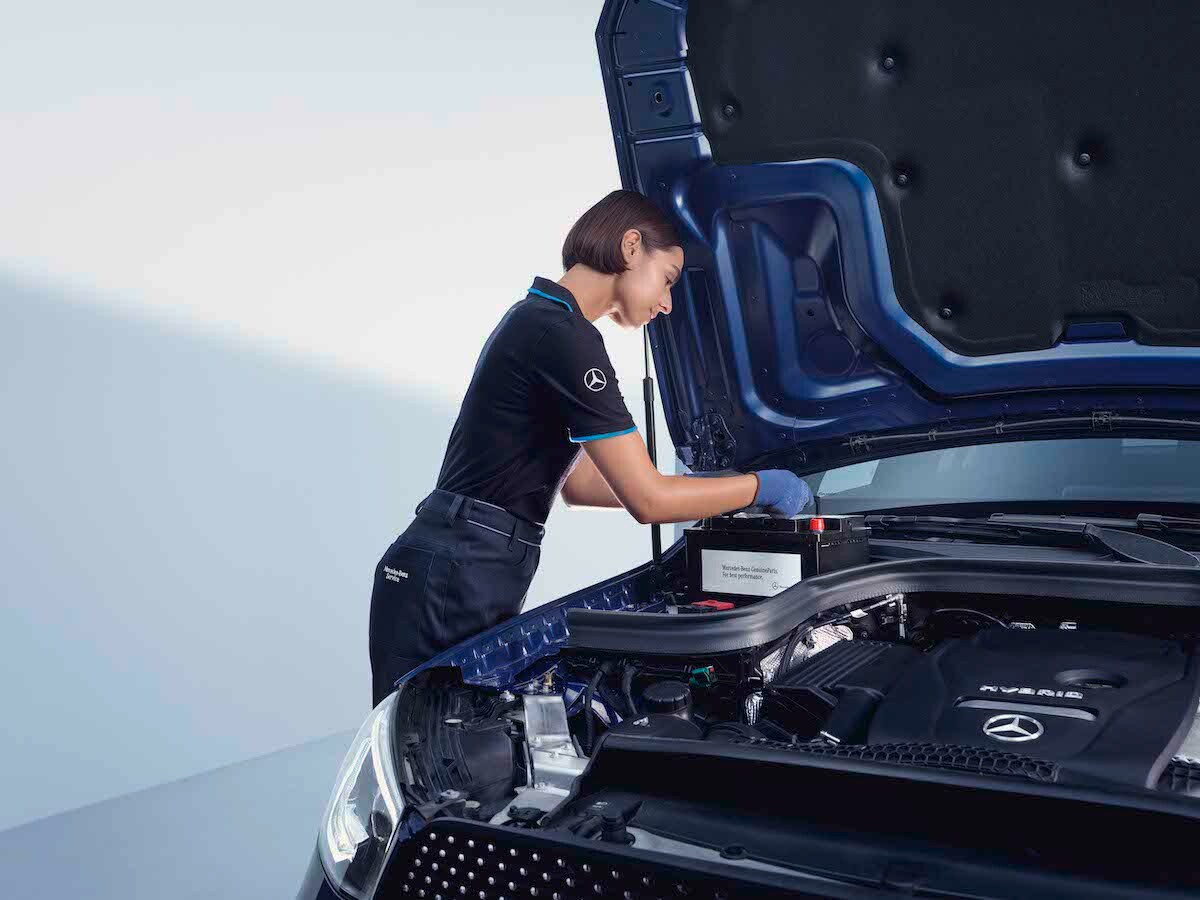 Une technicienne Mercedes-Benz vérifie une batterie de voiture.