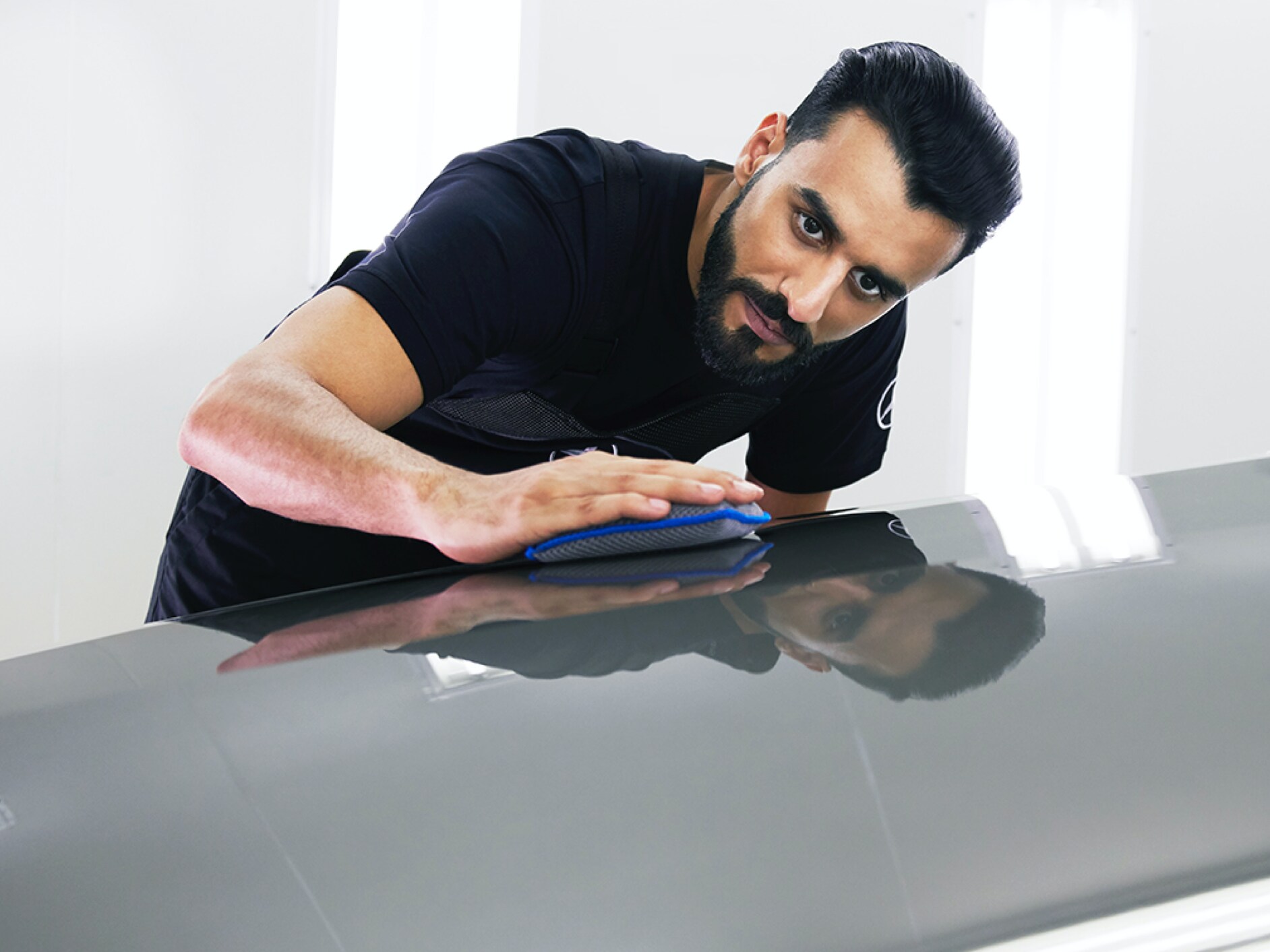 Un technicien Mercedes-Benz vérifie que le capot ne présente pas de petits dommages.