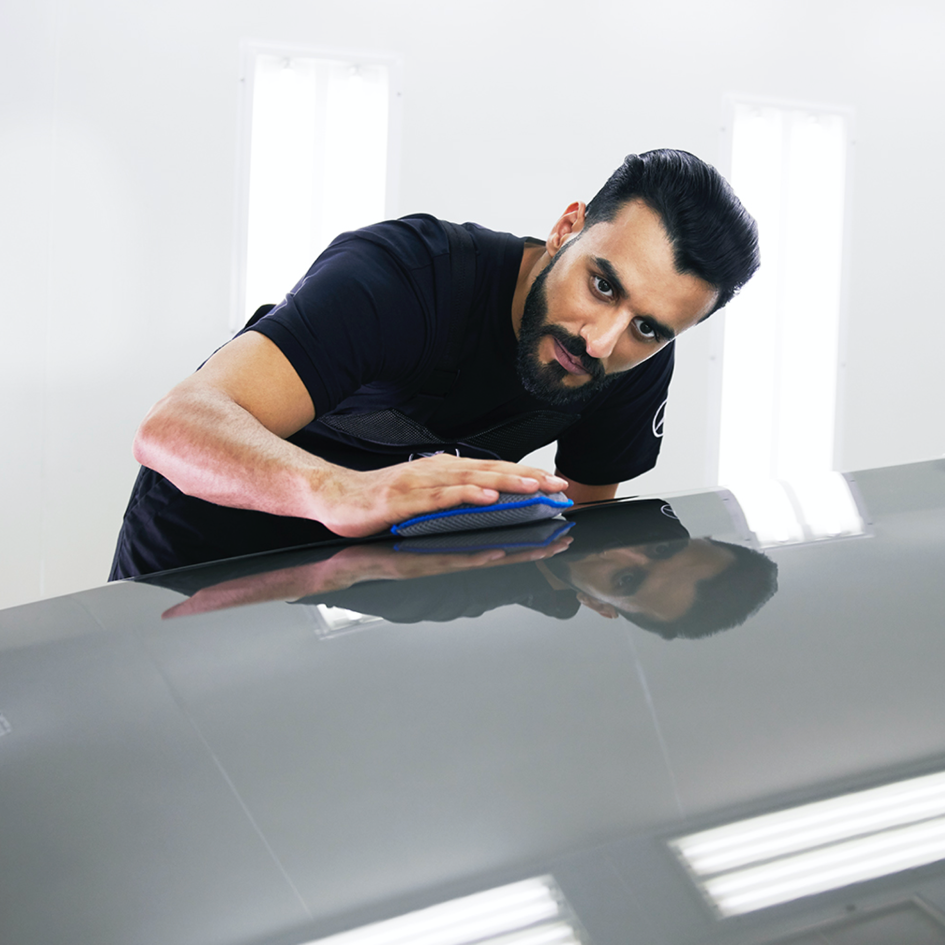 SmallRepair | Mercedes-Benz Un technicien Mercedes-Benz vérifie que le capot ne présente pas de petits dommages.