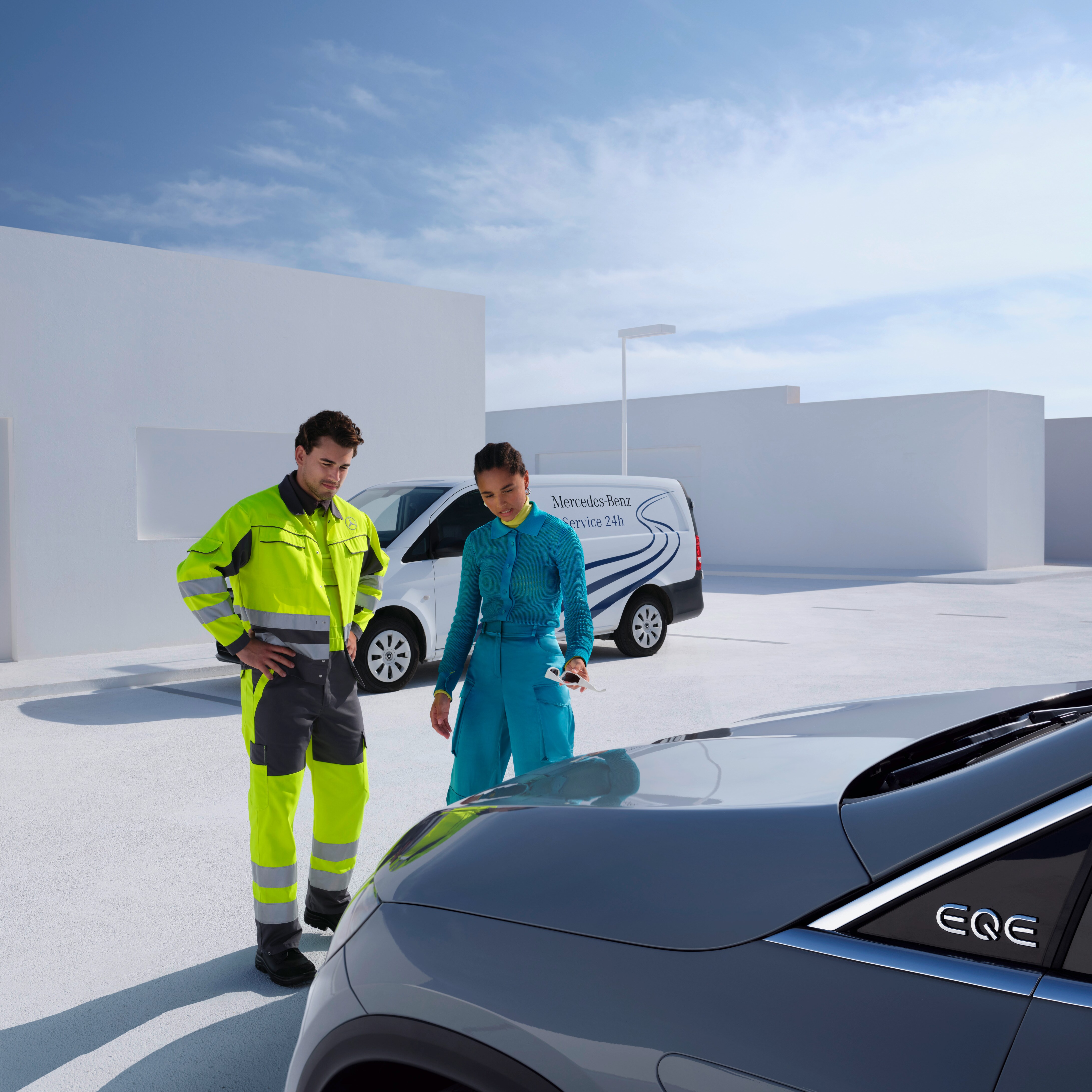Un technicien de l'équipe de service Mercedes-Benz et une personne regardant une Mercedes-Benz.