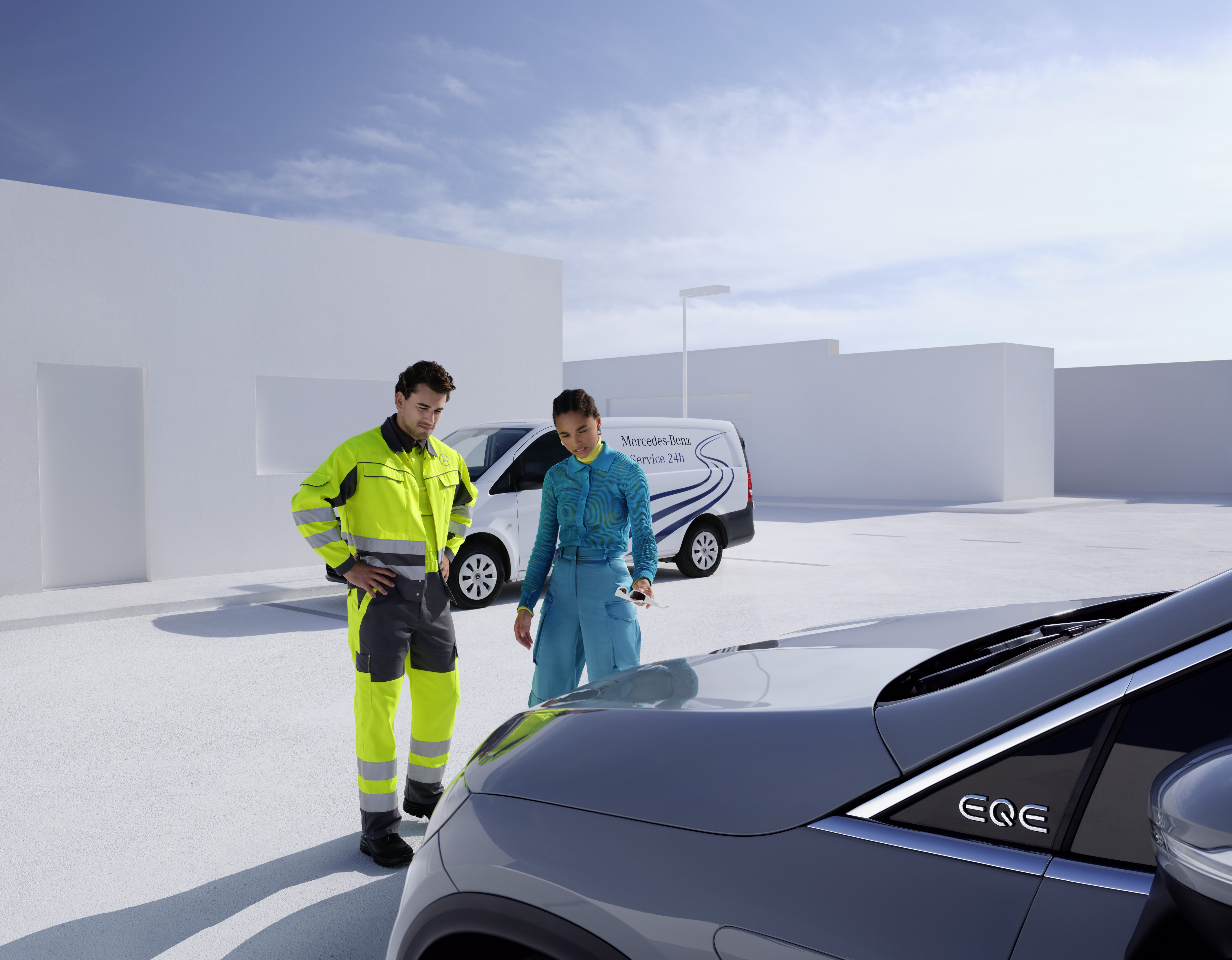 Assistance dépannage | Mercedes-Benz Un technicien de l'équipe de service Mercedes-Benz et une personne regardant une Mercedes-Benz.