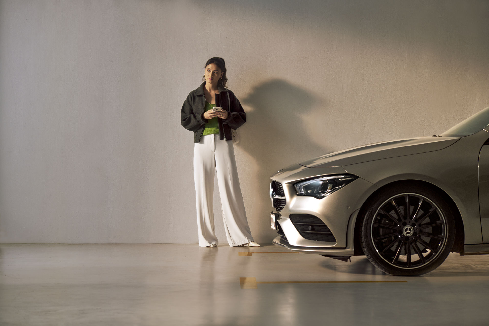 Service Select | Mercedes-Benz Een vrouw staat voor een Mercedes-Benz.