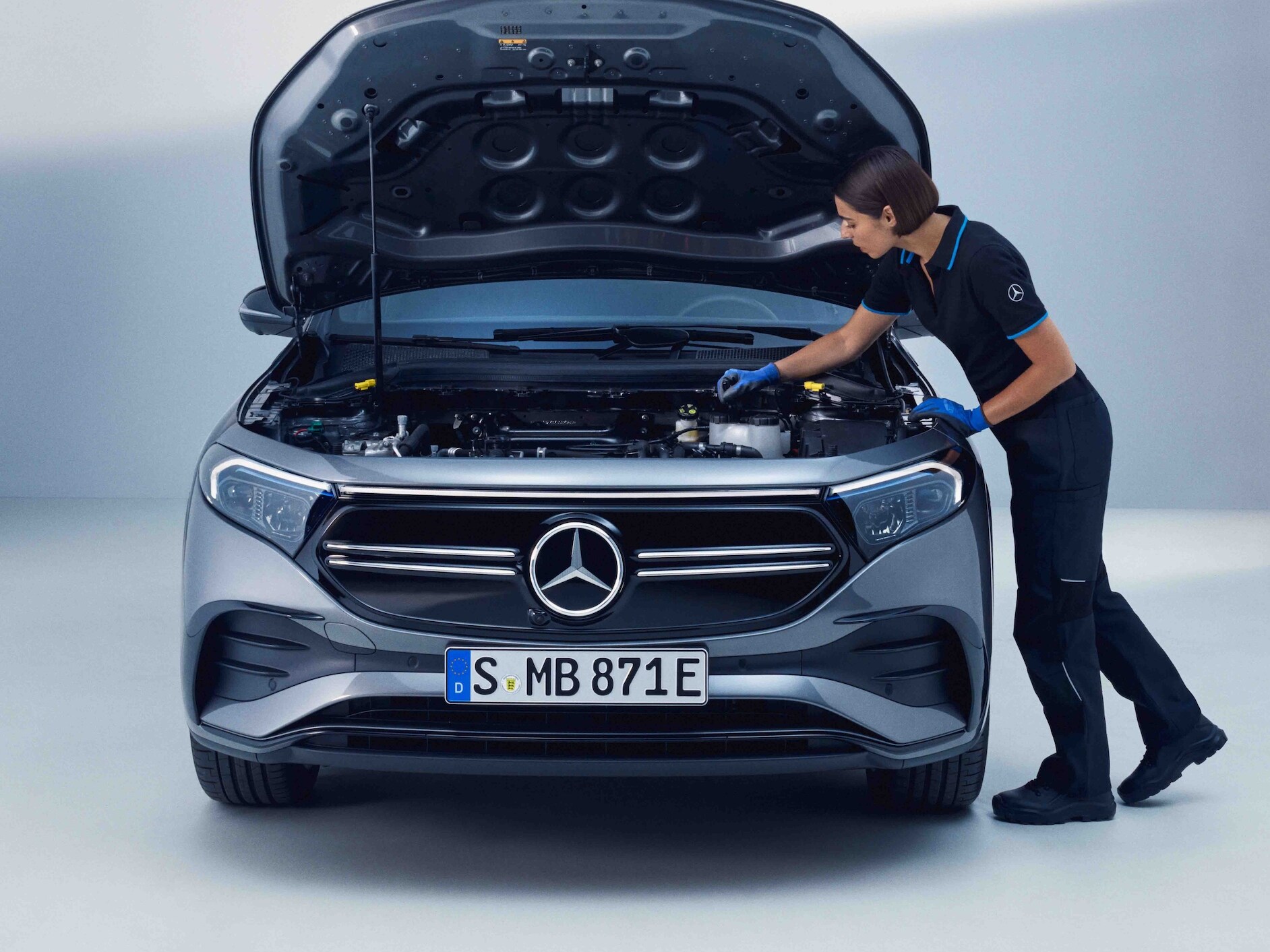 Een Mercedes-Benz technicus controleert een elektrische modellen van Mercedes-Benz.