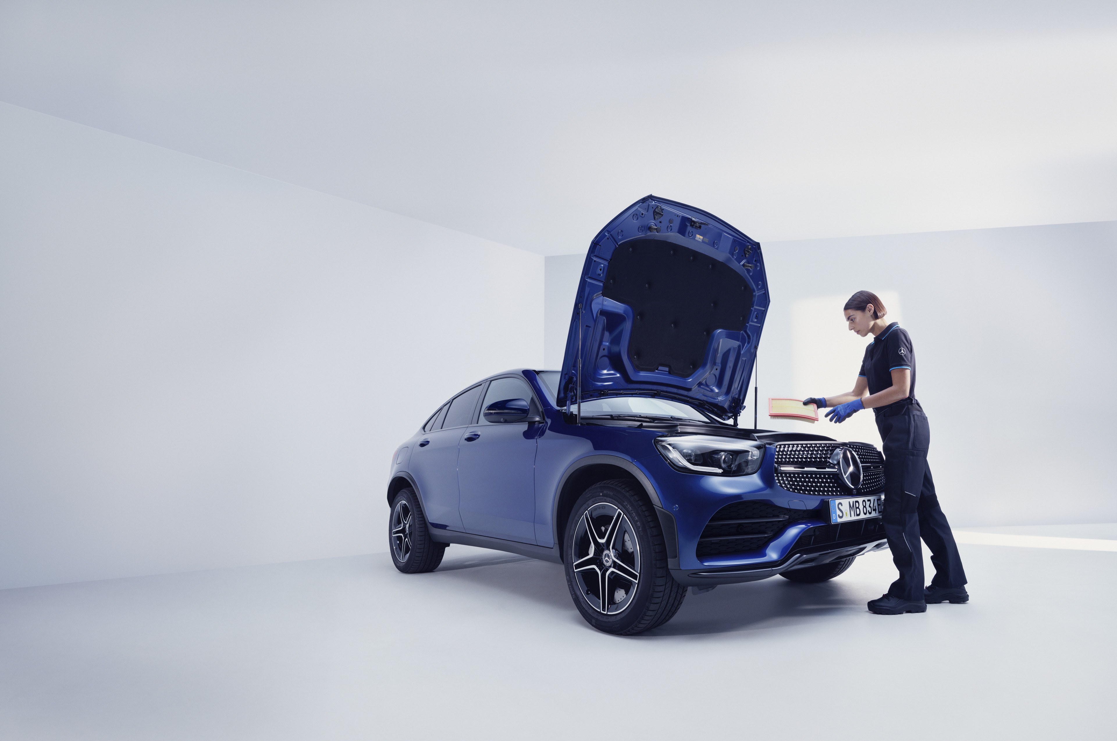Services de maintenance de Mercedes-Benz Un mécanicien Mercedes-Benz et un homme se tiennent devant le capot ouvert d'une Mercedes-Benz.
