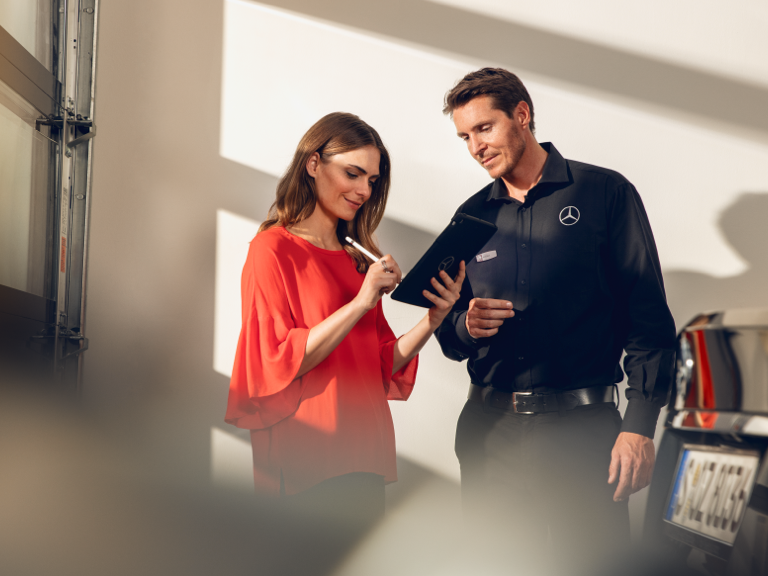 Schade online melden Een klant vult samen met een Mercedes-Benz technicus een formulier op een tablet in.