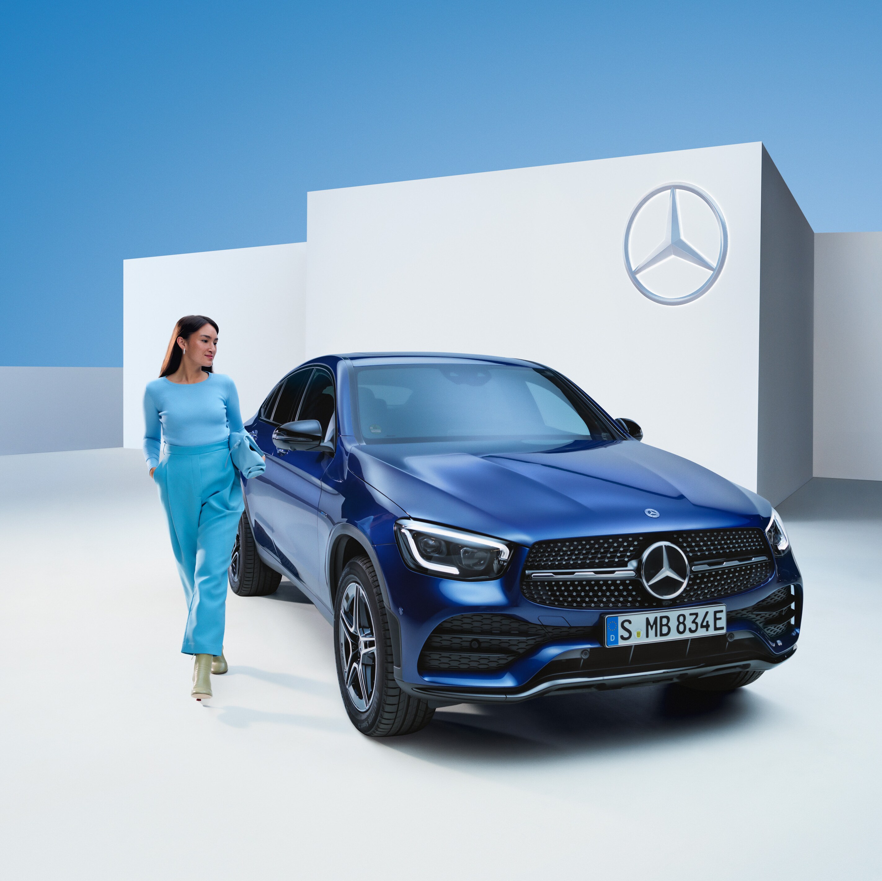 Une femme détendue à côté de sa Mercedes.