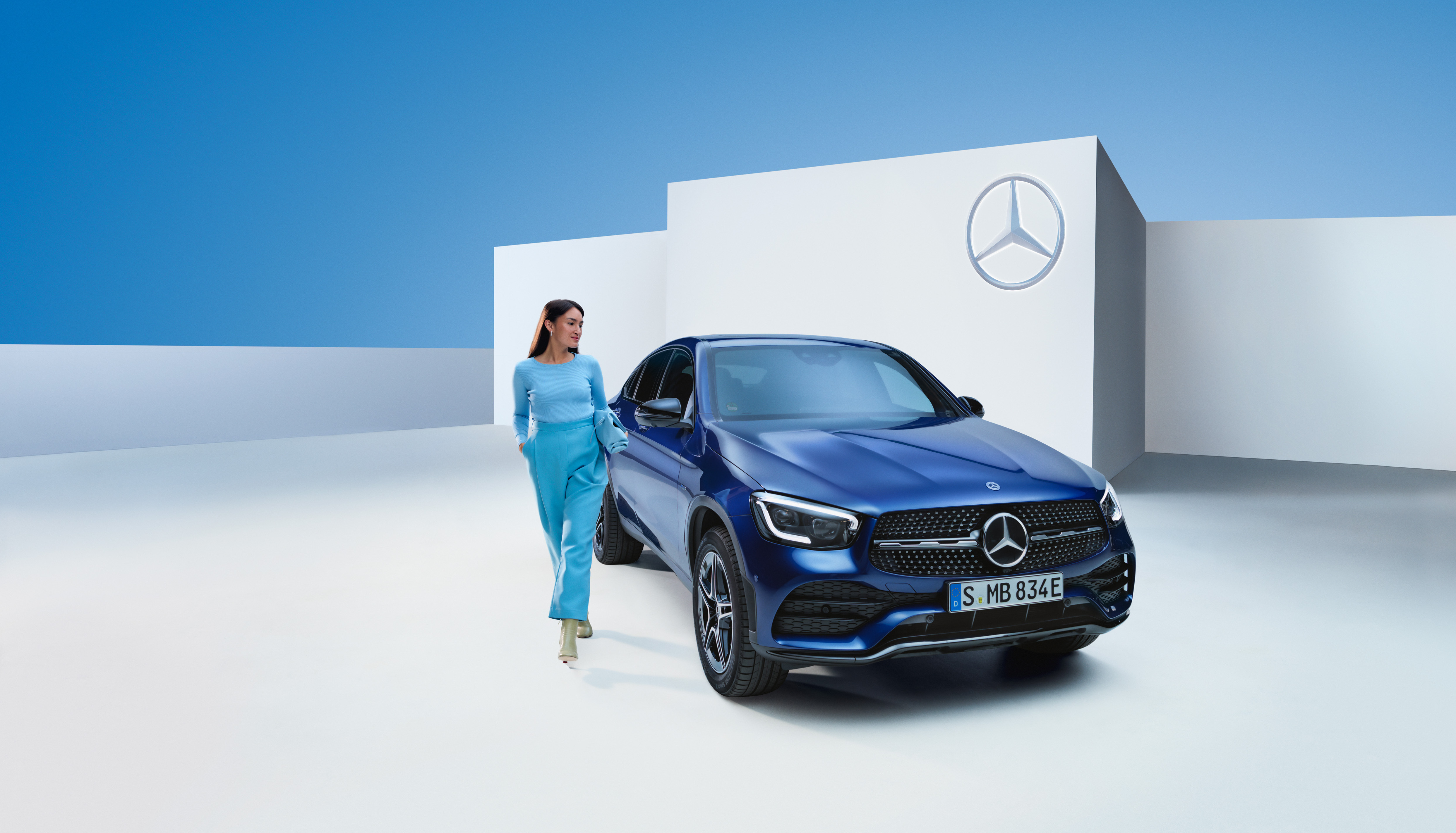 Monter à bord du véhicule en toute tranquillité, grâce à la garantie Mercedes-Benz. | Mercedes-Benz Une femme détendue à côté de sa Mercedes.