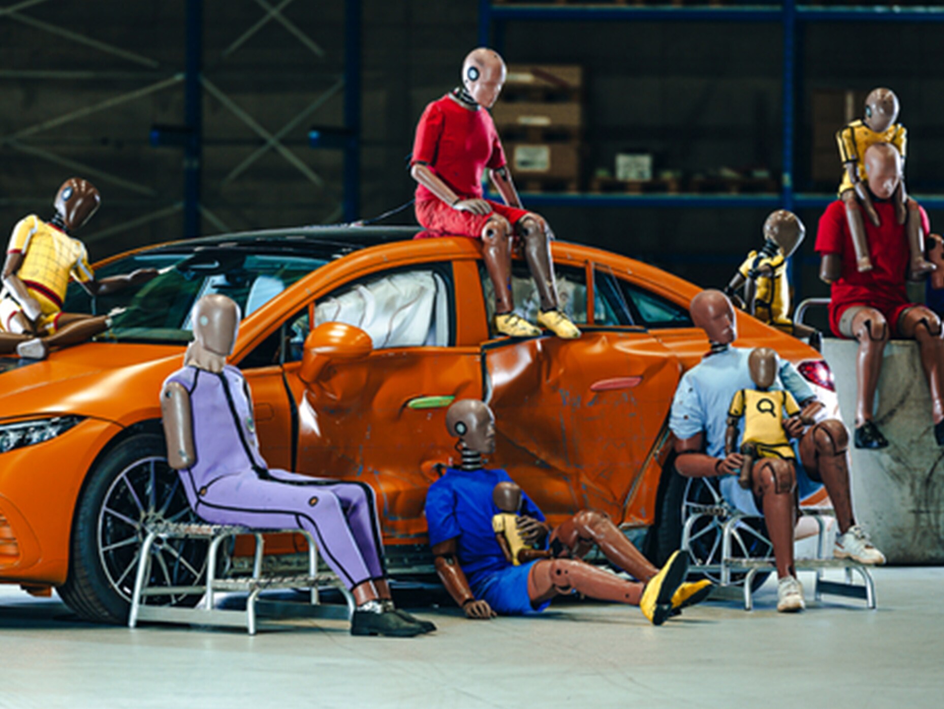 Plusieurs mannequins d’essai de collision assis sur et autour d'une voiture Mercedes-Benz.
