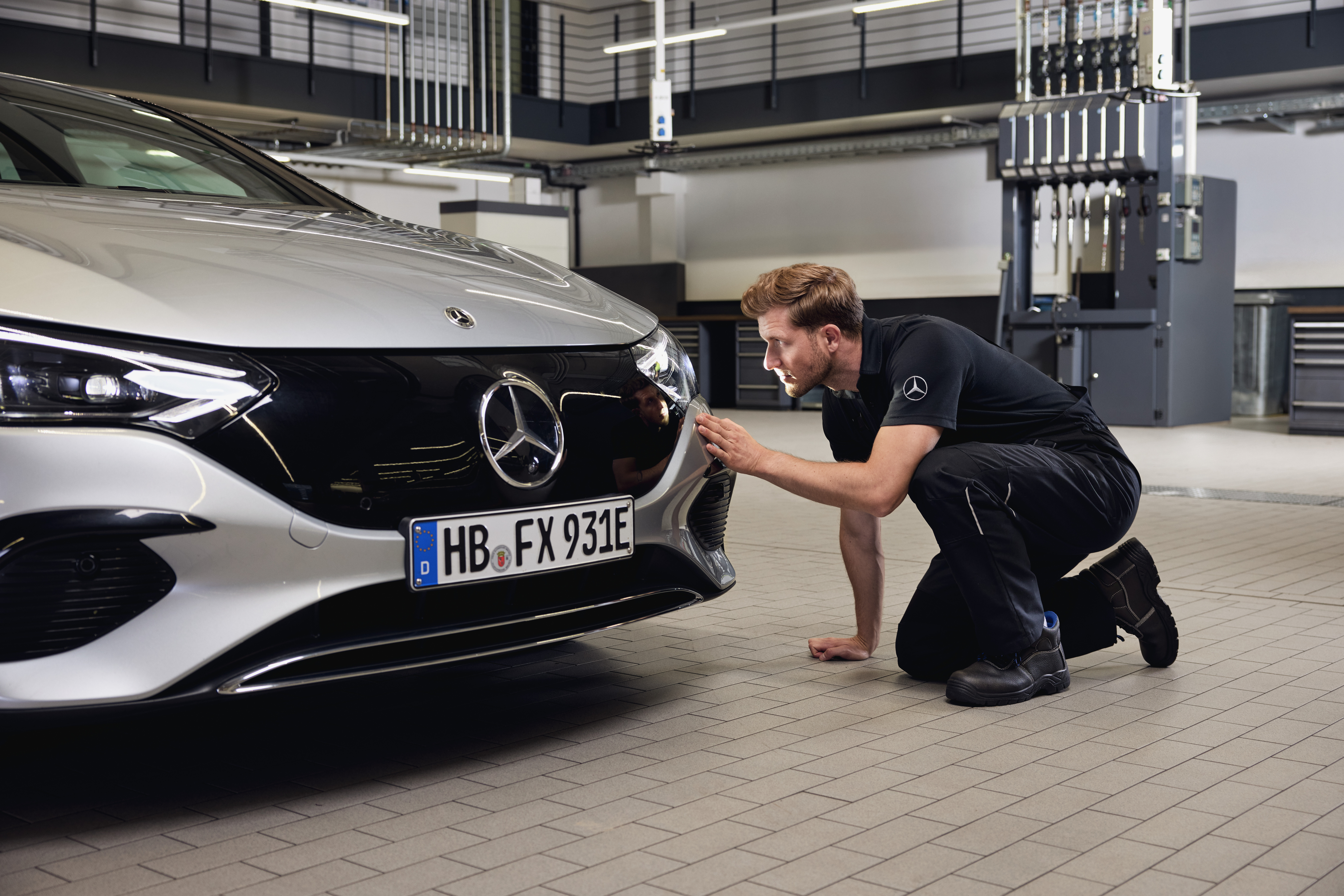 Mercedes-Benz originele koplampen vervangen Close-up van de voorzijde van een Mercedes-Benz voertuig met een monteur die een gedetailleerd onderzoek uitvoert naar de vervanging van Mercedes-Benz originele onderdelen.