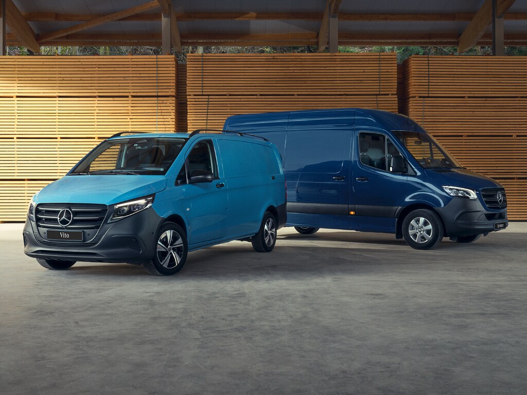 Deux fourgons Mercedes-Benz bleus dans un entrepôt en bois.