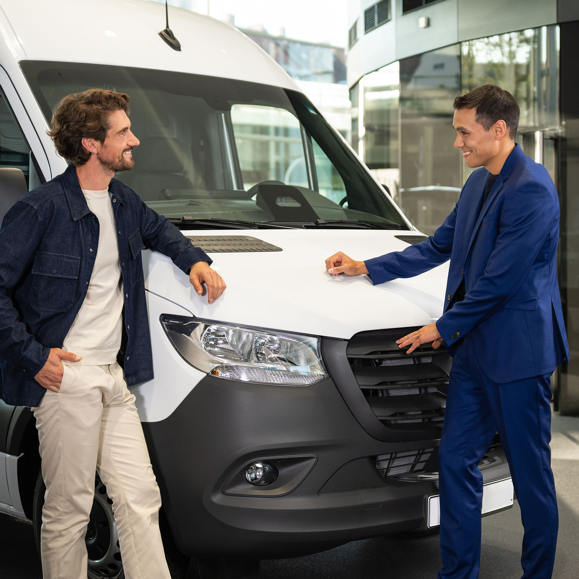 Verzekering voor uw Mercedes-Benz Bedrijfswagen Twee personen leunen tegen een Mercedes-Benz bestelwagen en zijn in gesprek.