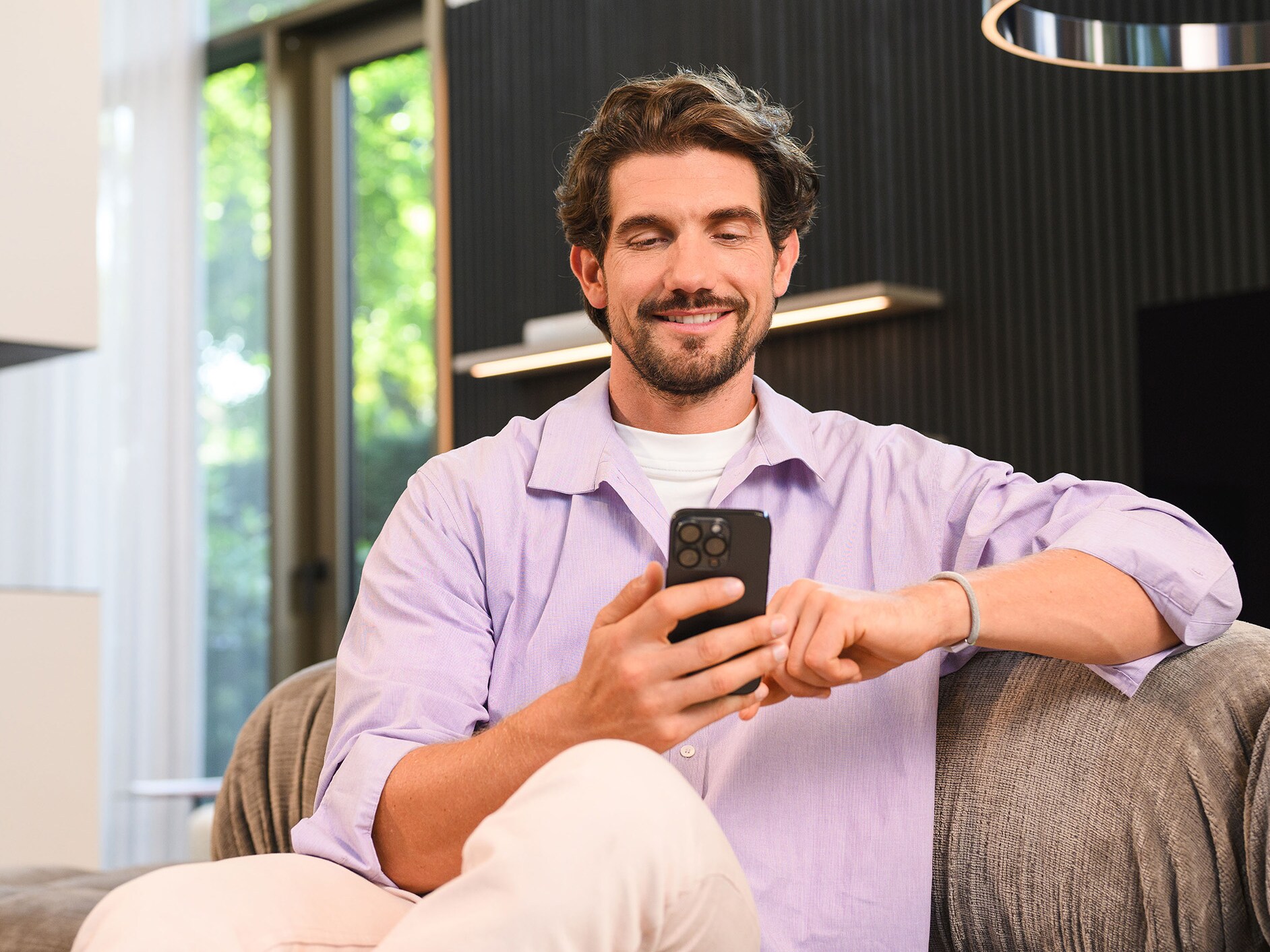 Une personne assise utilisant un appareil mobile.​