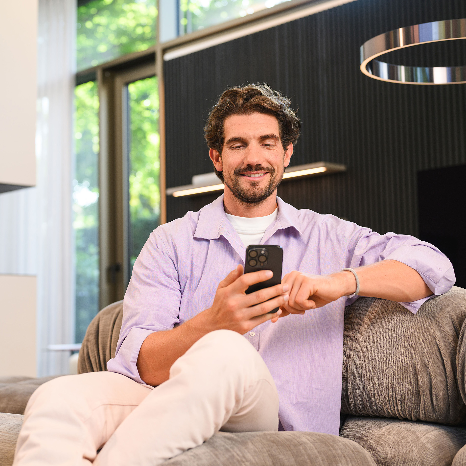 Man raadpleegt informatie op zijn smartphone. Man bekijkt zijn smartphone om de Mercedes-Benz website te raadplegen.