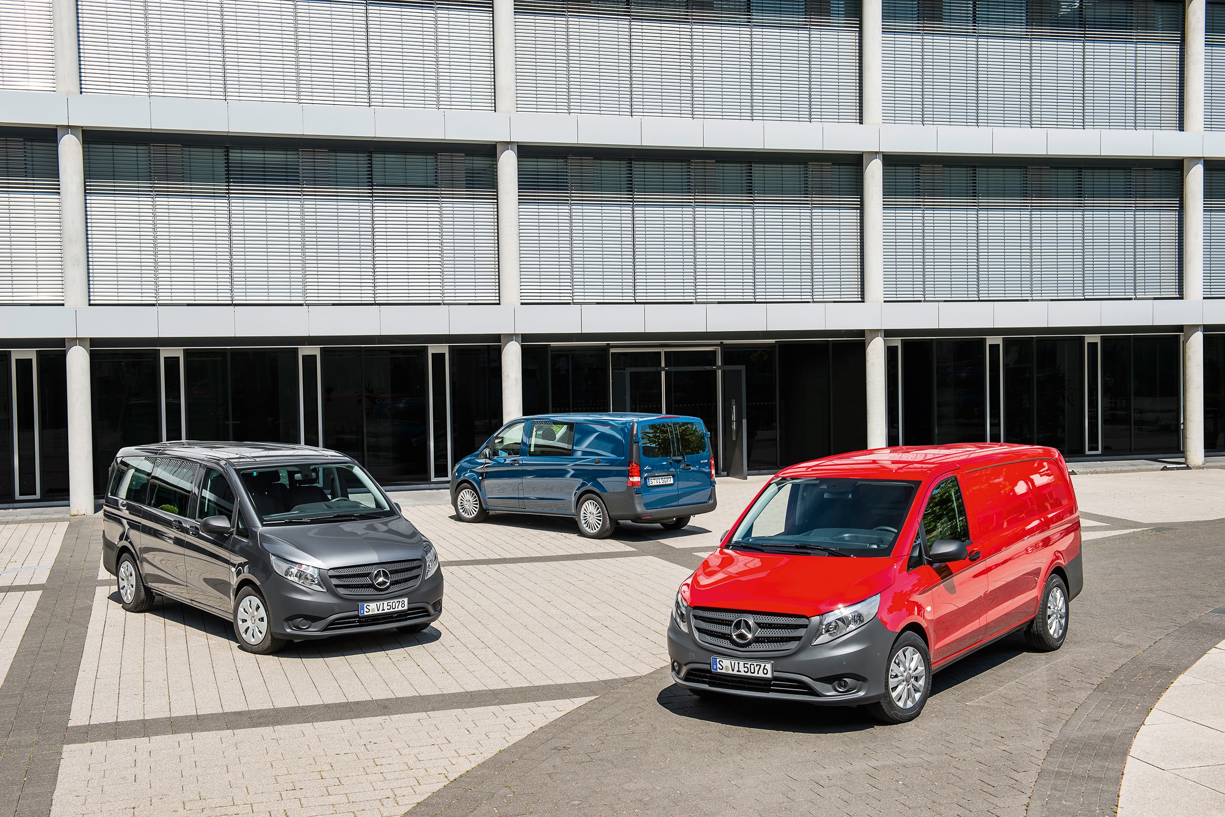 La troisième génération de Mercedes-Benz Vito | Histoire des véhicules industriels | Mercedes-Benz Plusieurs Mercedes-Benz Vito garés devant un immeuble de bureaux moderne