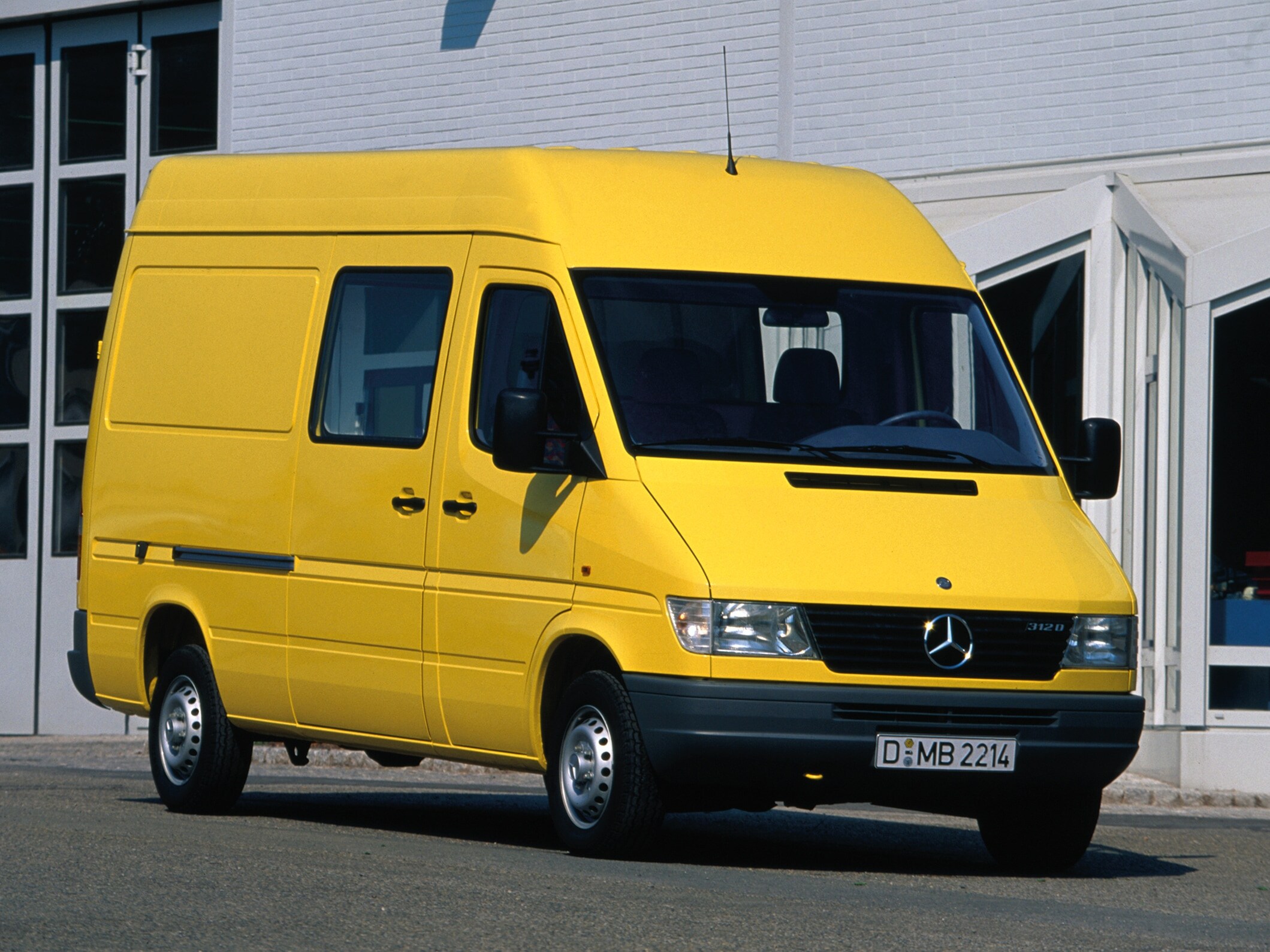 Un Sprinter de première génération garé devant un bâtiment industriel