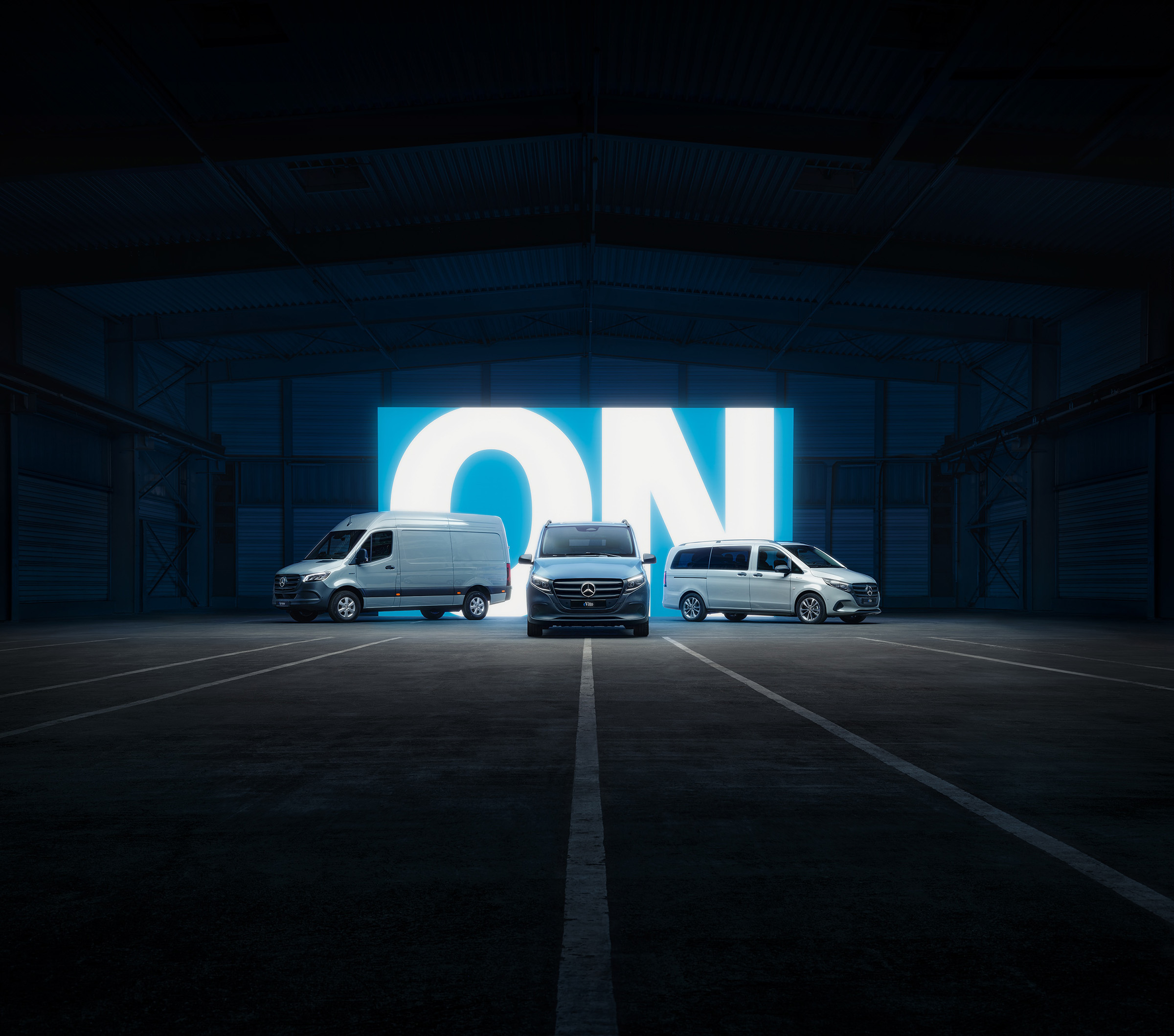 Elektrische actieradius | Alle Sprinter-modellen | Mercedes-Benz Bestelwagens Het assortiment elektrische bestelwagens van Mercedes‑Benz, met de eSprinter en de eVito, in een verlichte showroom.