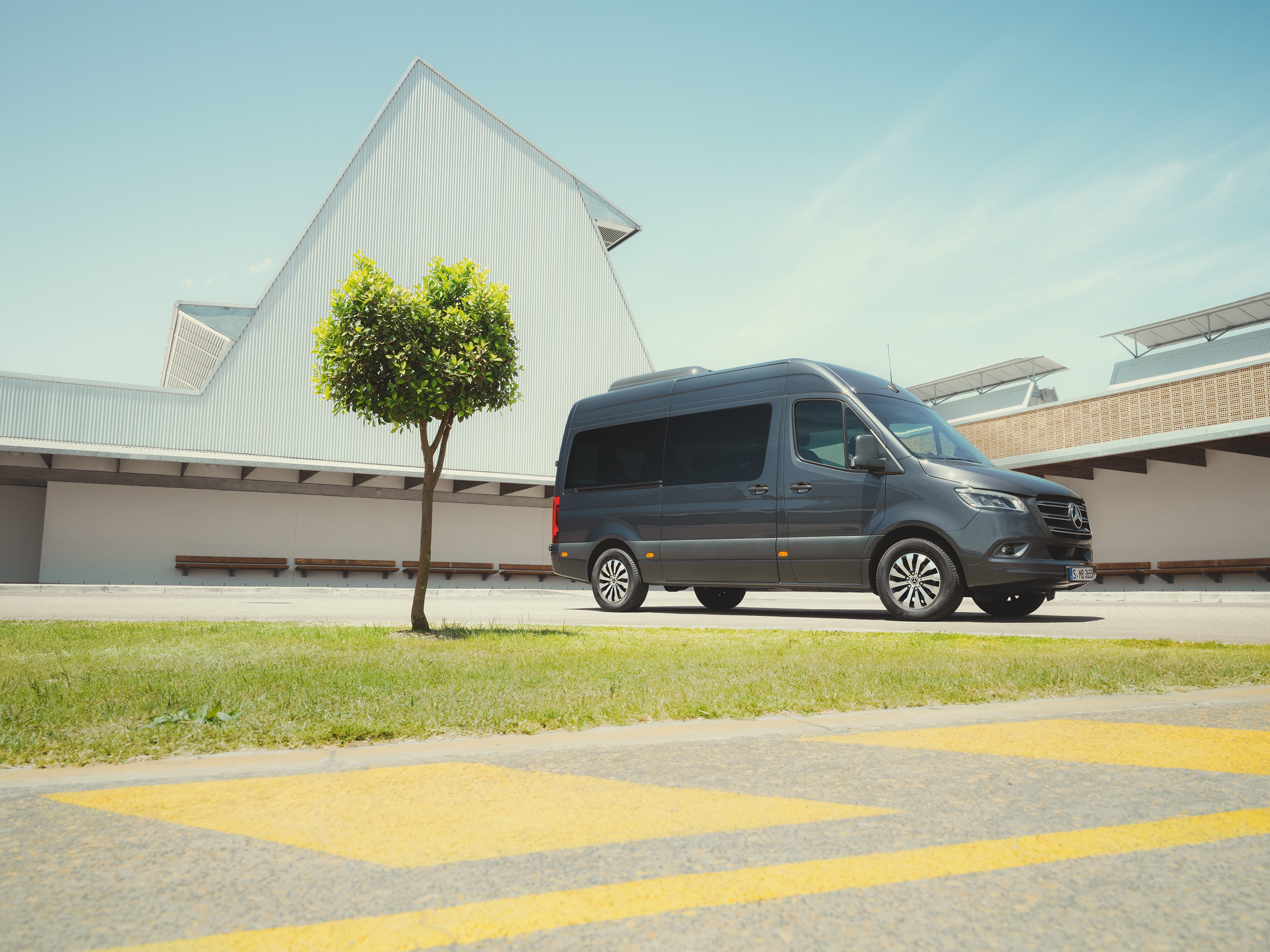 Sprinter Tourer | Alle Sprinter-modellen | Mercedes-Benz Bestelwagens Mercedes‑Benz Sprinter Tourer in een stedelijke omgeving, waarbij de nadruk ligt op hoogwaardig personenvervoer