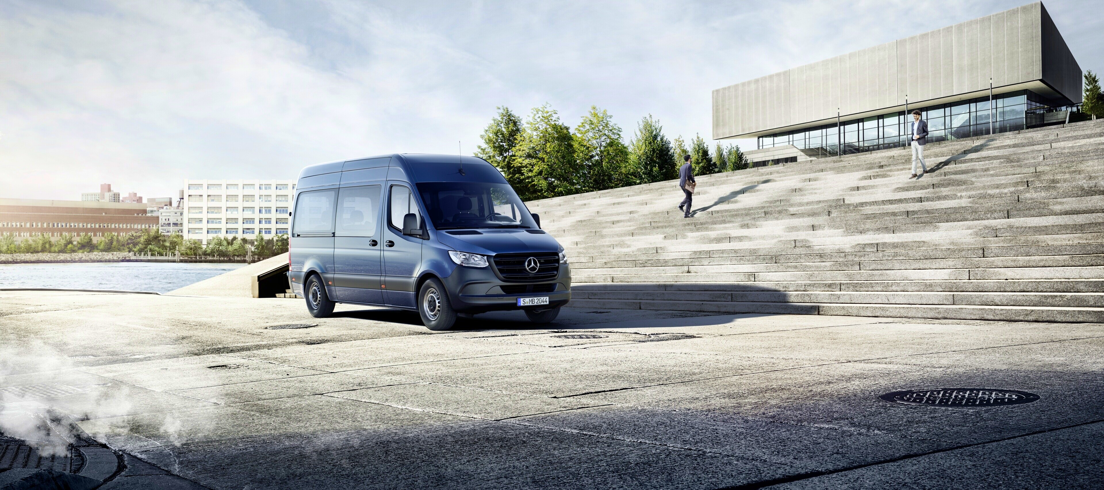 Modelvergelijking | Sprinter Tourer | Mercedes-Benz De Mercedes-Benz Sprinter Tourer voor een gebouw.