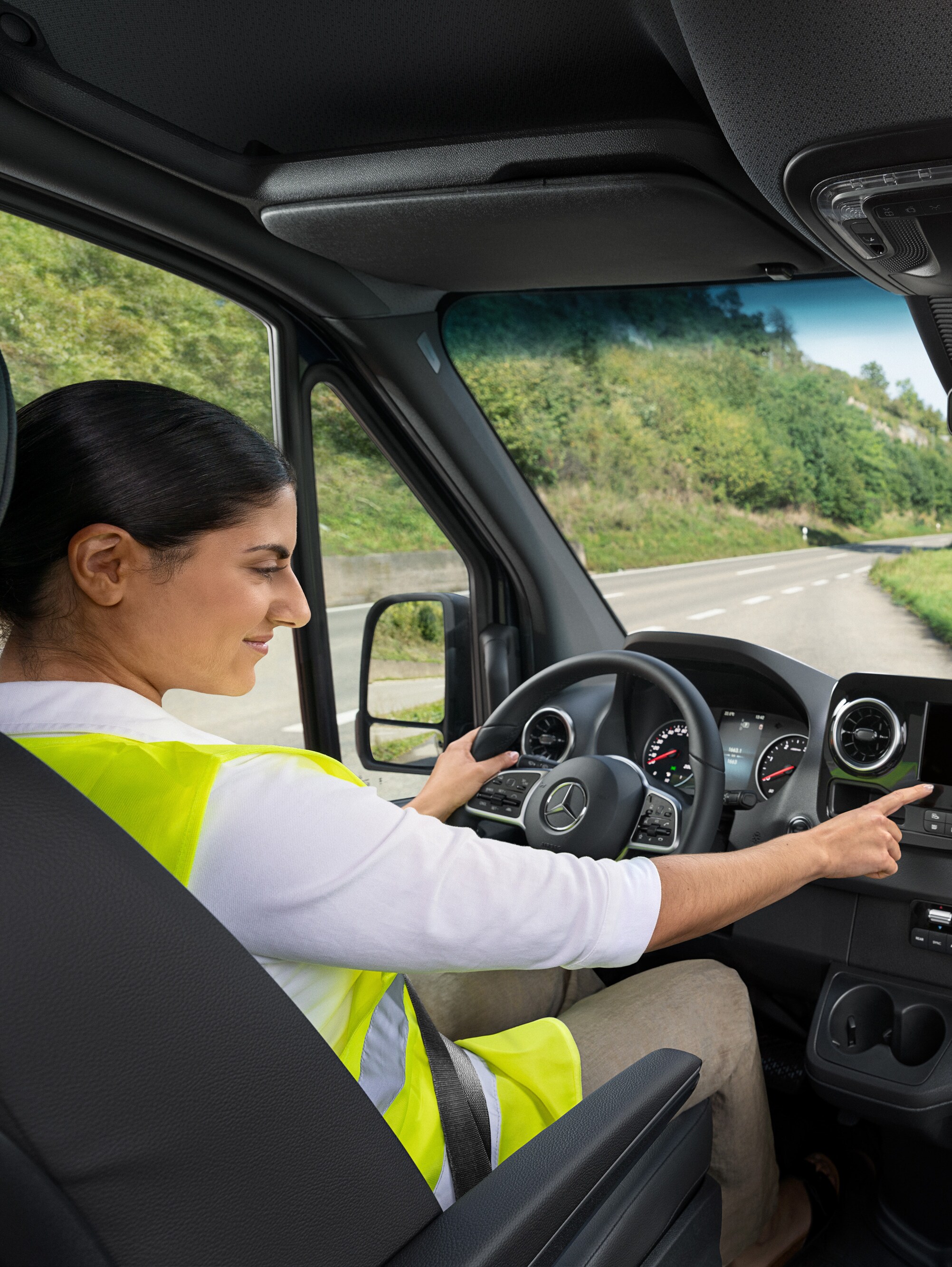 Bestuurster in een Mercedes-Benz Sprinter Gesloten Bestelwagen belt bij een storing de Mercedes-Benz Service24h-hotline via het voertuigmenu.