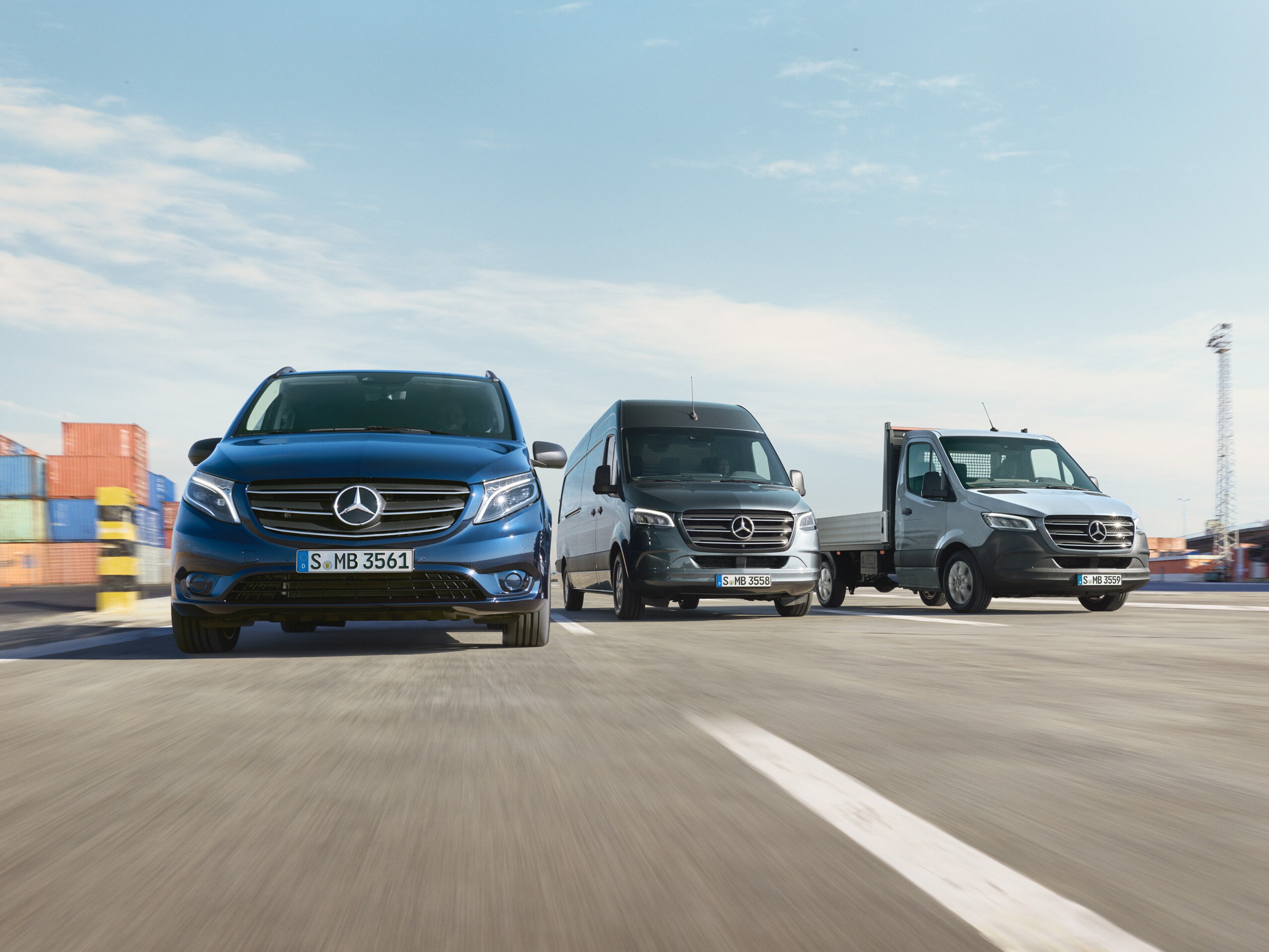Een reeks Mercedes-Benz bedrijfswagens die naast elkaar geparkeerd staan op een weg naast een laadkade.