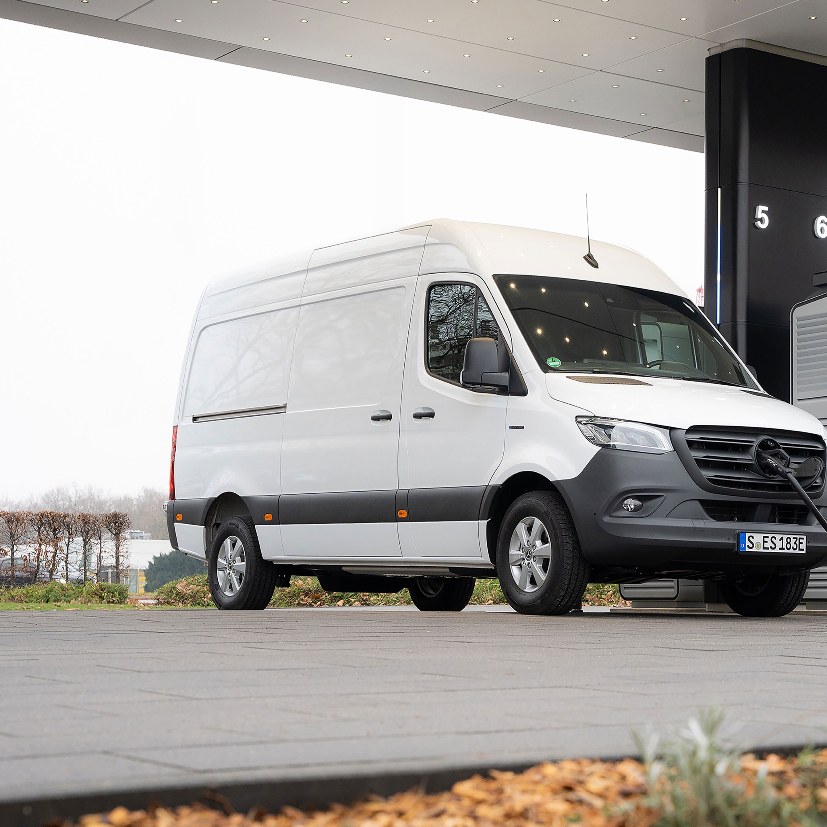 Un utilitaire léger Mercedes-Benz devant une borne de recharge pendant la recharge.